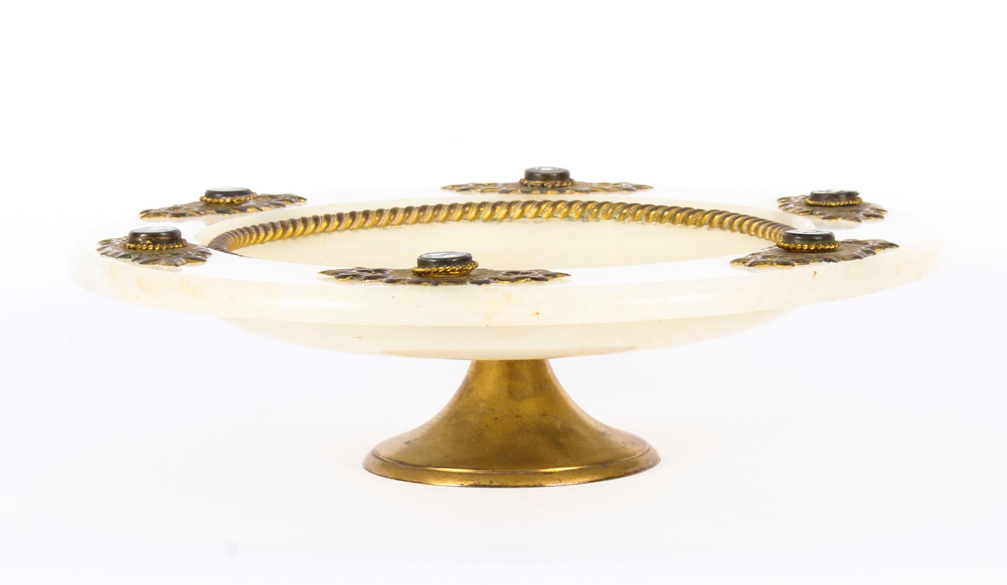 Il s'agit d'un superbe plat de table italien ancien de qualité, monté en Pietra Dura, en laiton doré et en albâtre, datant de la fin du XIXe siècle.

Avec de remarquables montures en laiton ciselé percées de style néo-gothique, ce splendide plat