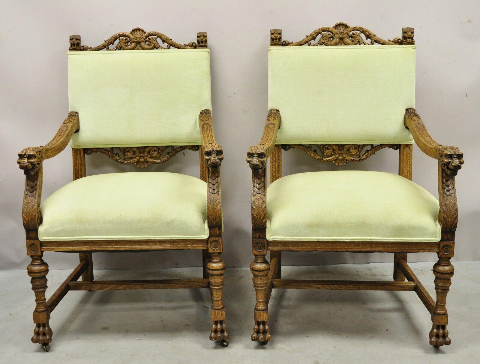 Antique Italian Renaissance Carved Oak Wood Lion Head Paw Feet Arm Chairs - Pair. Item features wonderfully carved details, green upholstery, very nice antique pair. Circa 1900. Measurements: 43