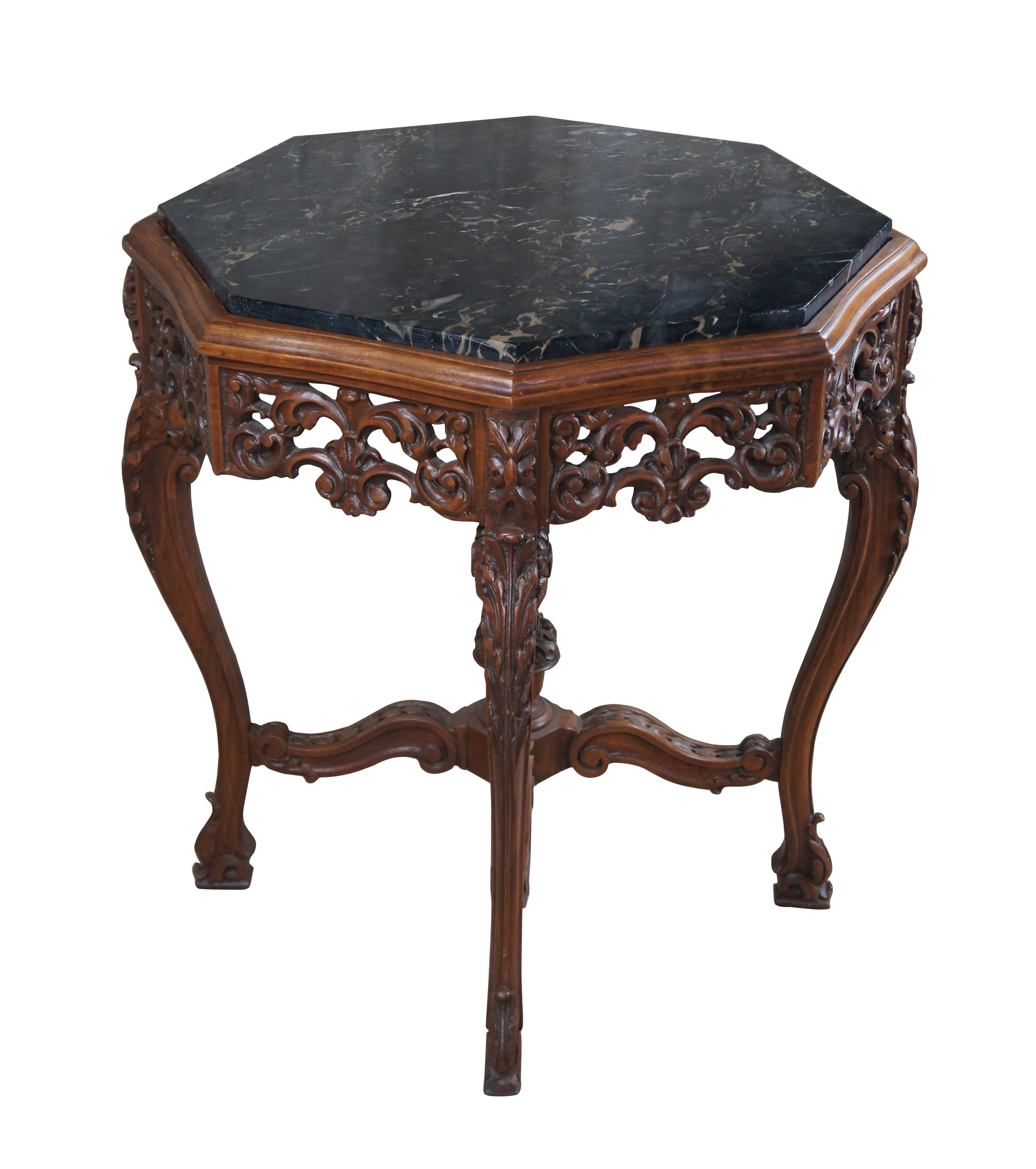 Antique Italian Renaissance center (centre) or side table. Features an octagonal frame carved from walnut with a pierced foliate apron over four acanthus carved downswept legs leading to footed and scrolled feet. The legs are connected by thick