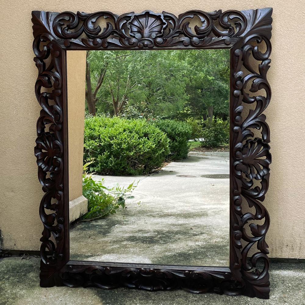 Antique Italian Renaissance Carved wood mirror is an intriguing design, with elegantly scrolled acanthus leaf motifs surrounding four boldly carved scallop shells centered on each side, all pierce-carved completely through the frame. The frame is