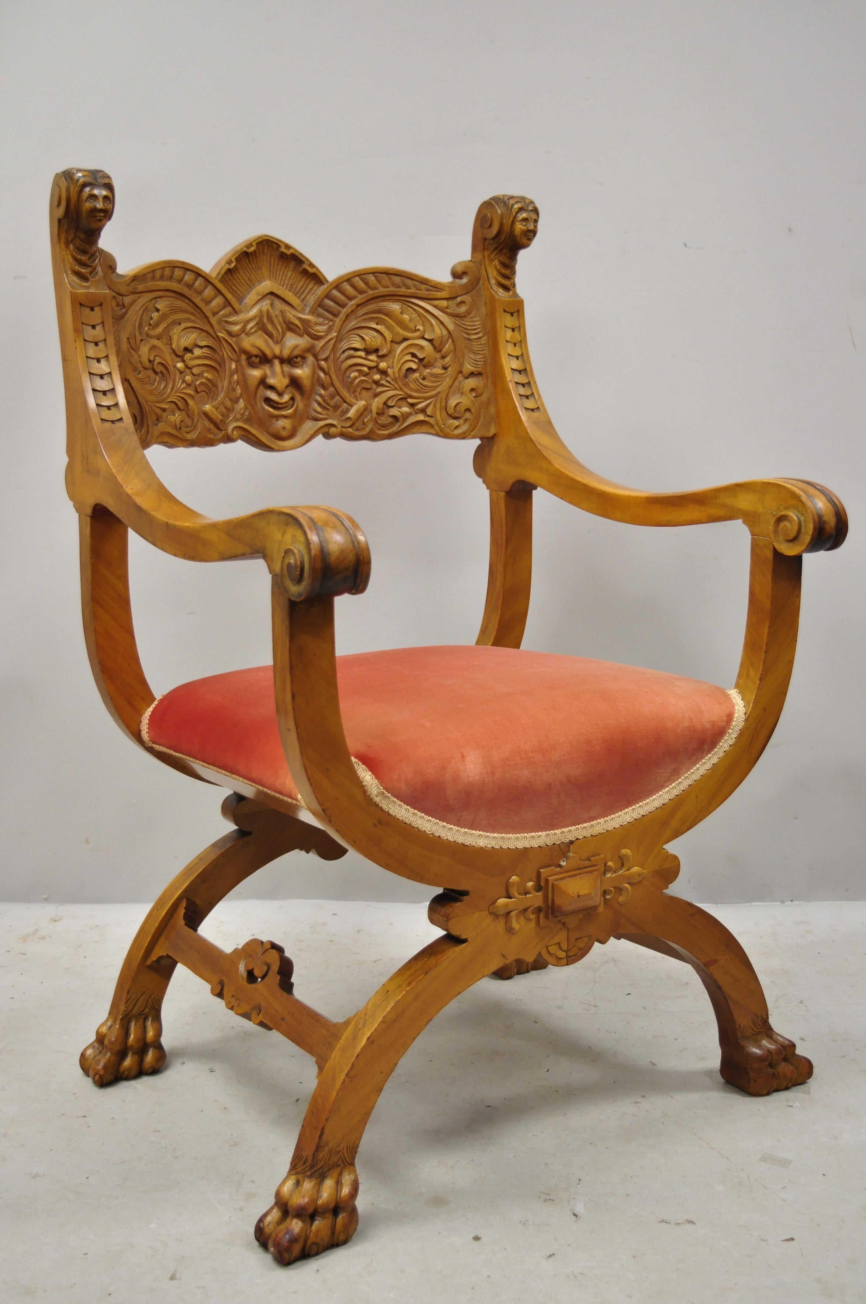 Antique Italian Renaissance figural carved mahogany & velvet curule throne armchair. Item features a carved face and leafy scrollwork, female faces to finials, paw feet, curule base, solid wood frame, beautiful wood grain, circa early 1900s.