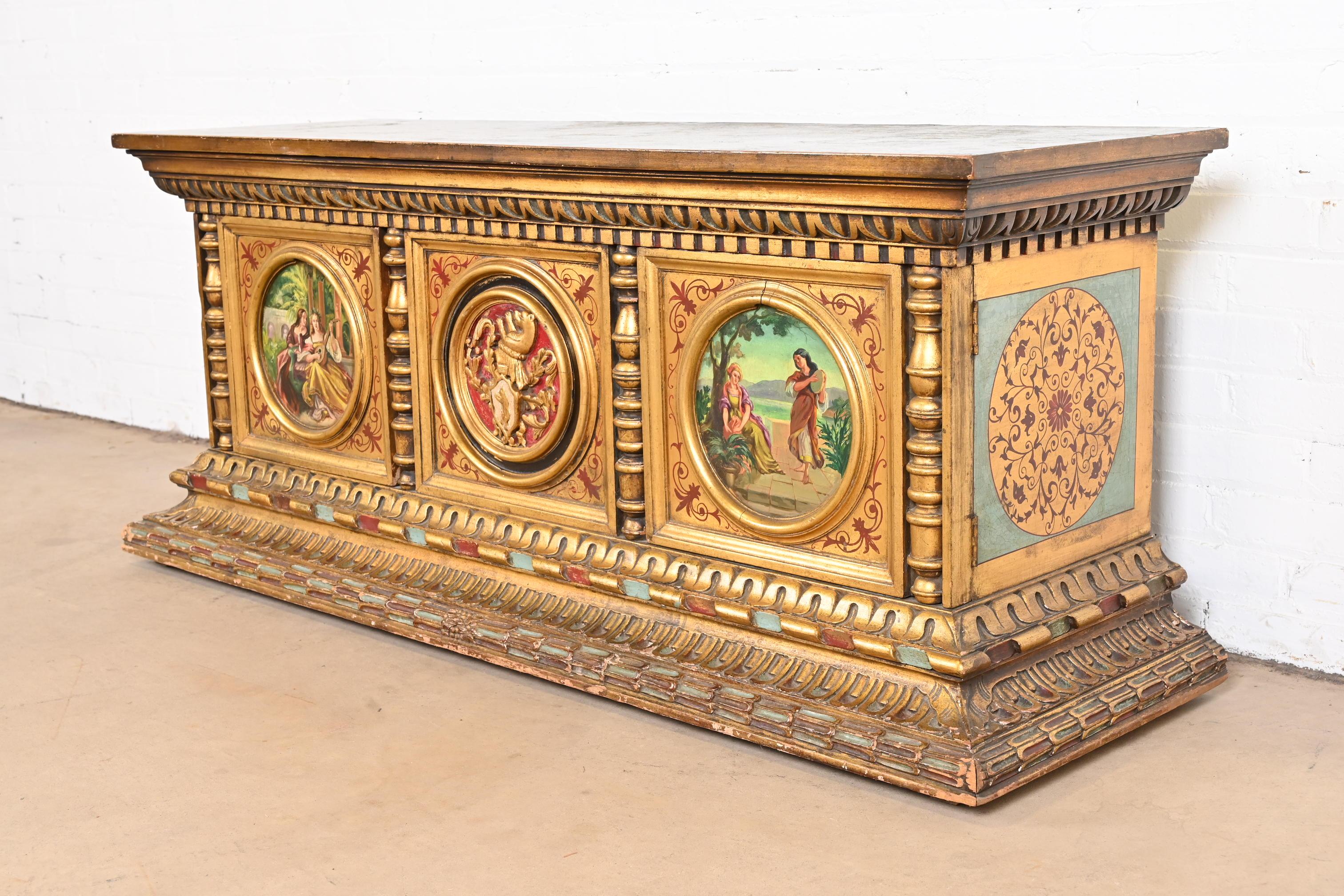 An exceptional antique Italian Renaissance style low cabinet or credenza

Italy, circa Late 19th century

Carved giltwood, with hand painted scenes, and painted faux marble top.

Measures: 58.75