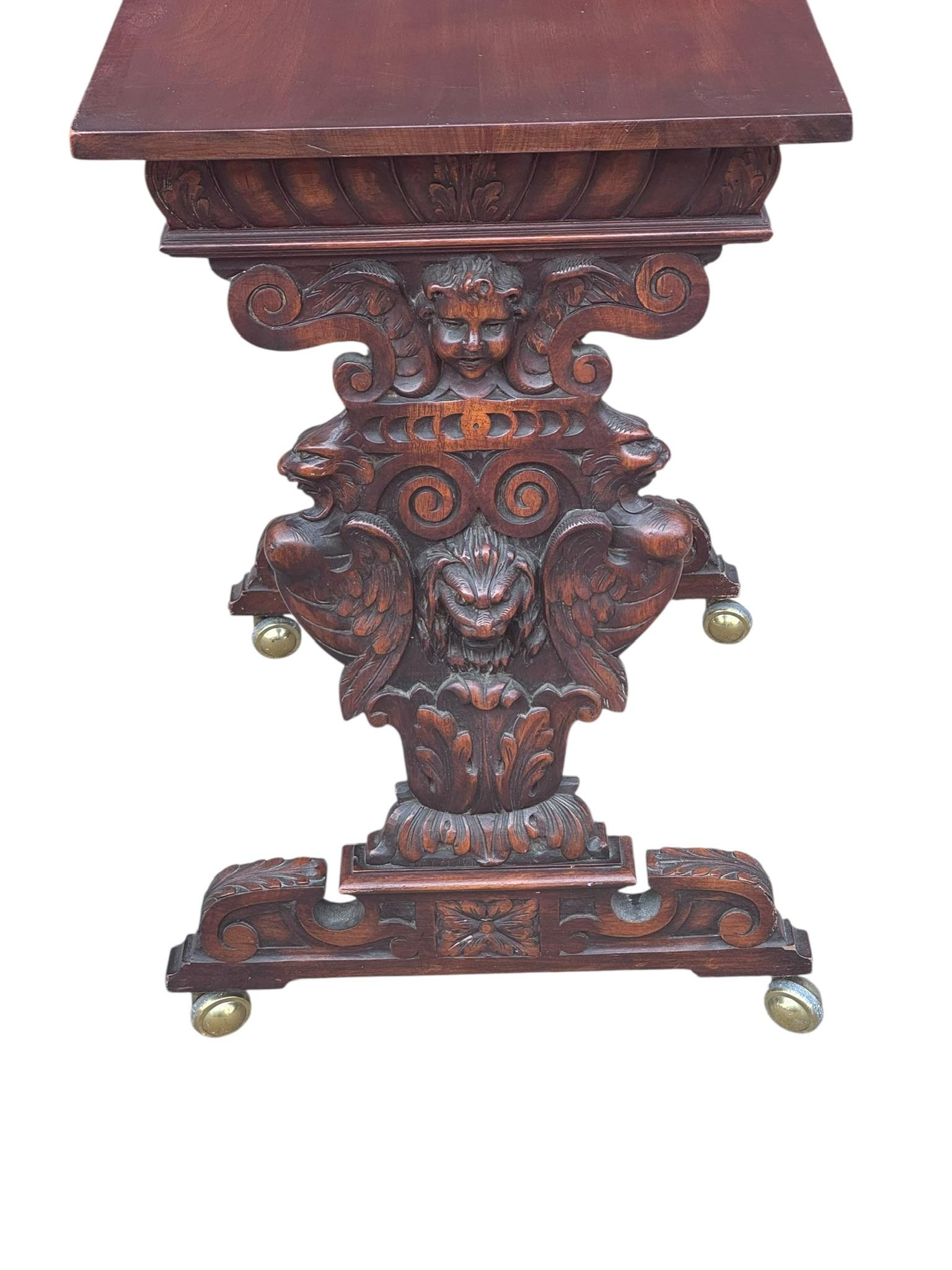 Antique Italian Renaissance Revival Carved Ornate Figural Bust, Winged Lions Head and Cherub Detailed Walnut Console Table

The sides of this Renaissance revival console table have been ornately carved with cherubs and winged lions. Brass casters