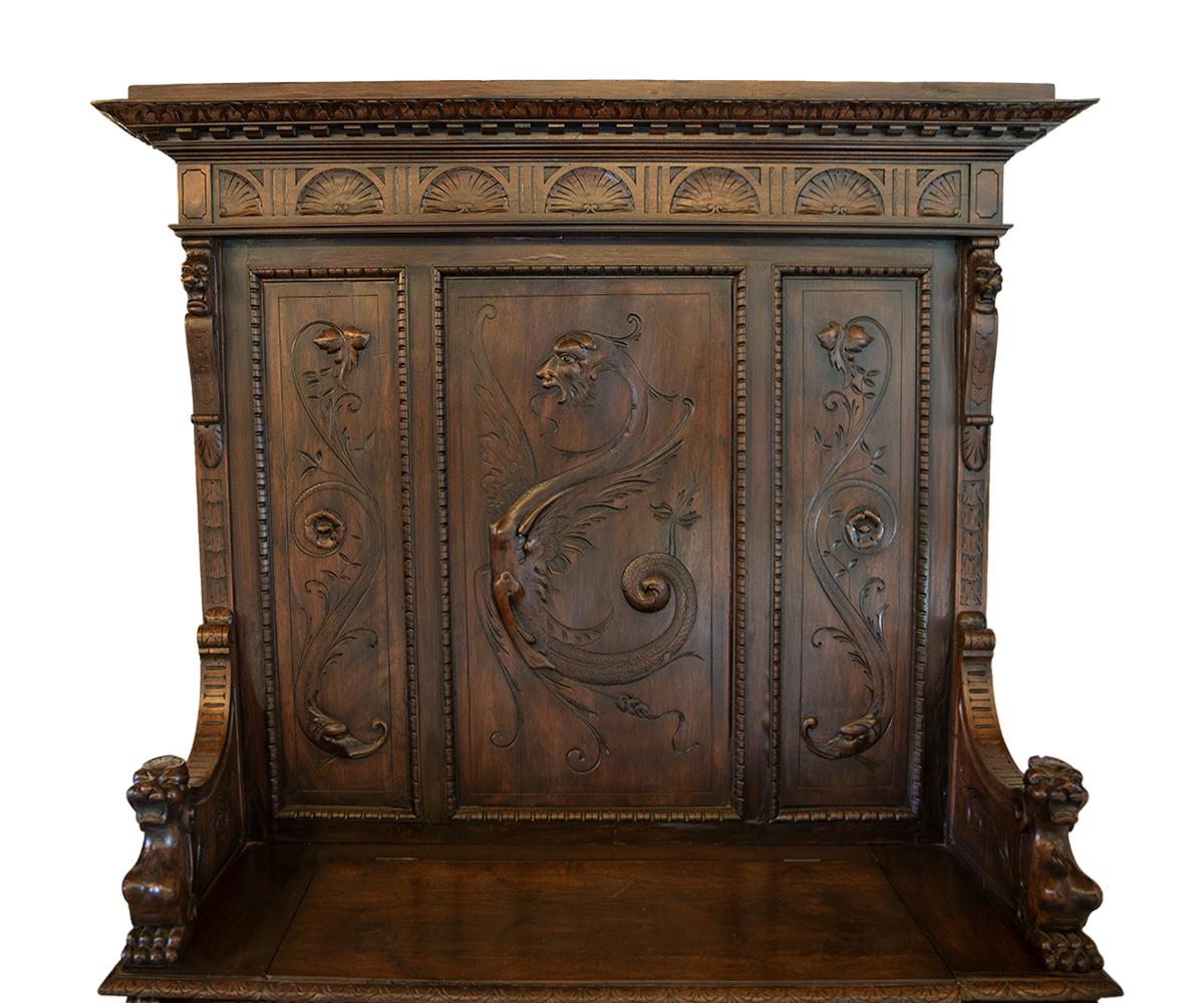 Offered this beautifully hand carved walnut Italian with high back and storage bench seat. It features a carved dragon on the back and supported lion face on each side with complimentary lion carvings for the armrests.