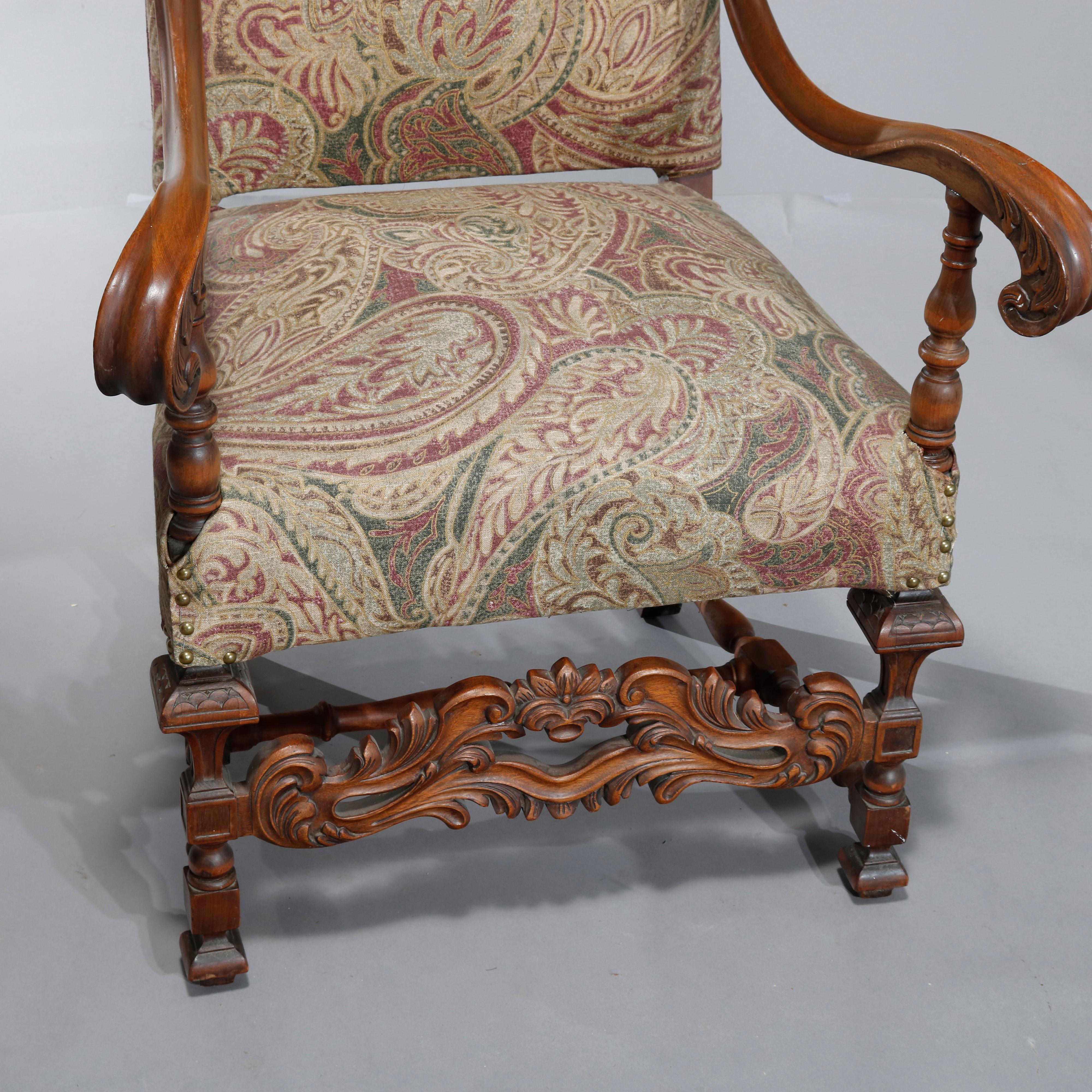 An antique Italian Renaissance Revival tall back throne chair offers walnut frame having shaped back and scroll form arms surmounting seat raised on balustrade legs with carved foliate and scroll stretcher, upholstered seat and back,