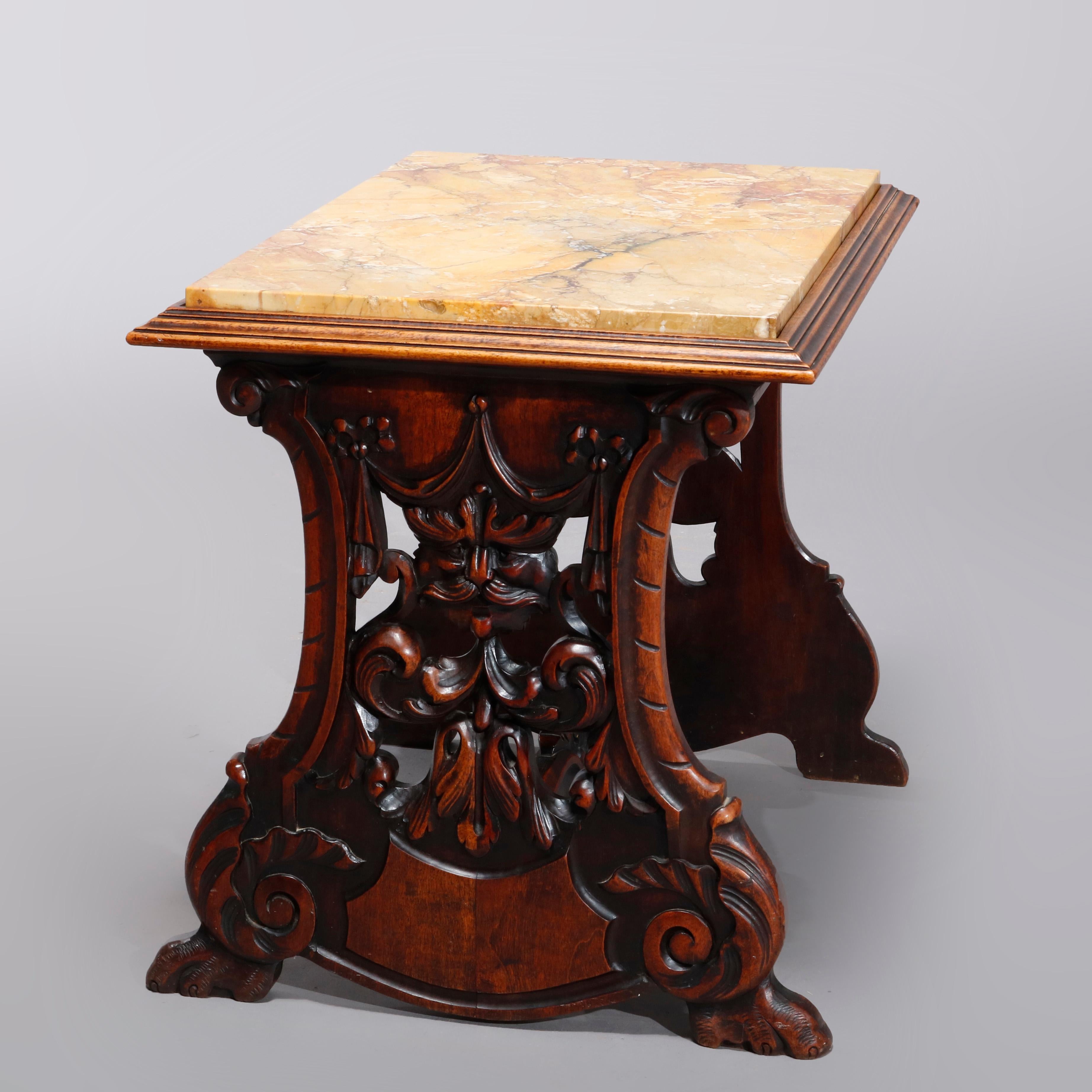 An antique Italian Renaissance Revival side table offers marble top surmounting trestle form walnut base having carved and pierced wind god masks and scroll form stretcher with carved foliate finial, circa 1900.

Measures: 20.25