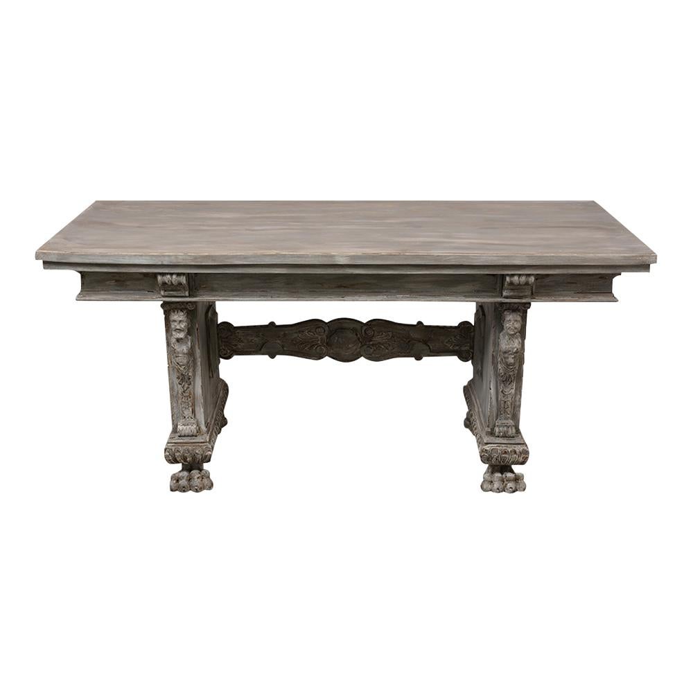 This antique Italian Renaissance-style Dining Room Table is made out of walnut wood and has been completely restored. Its been painted on a pale gray and off white color with a distressed finish. This dining table features a wooden top, detailed