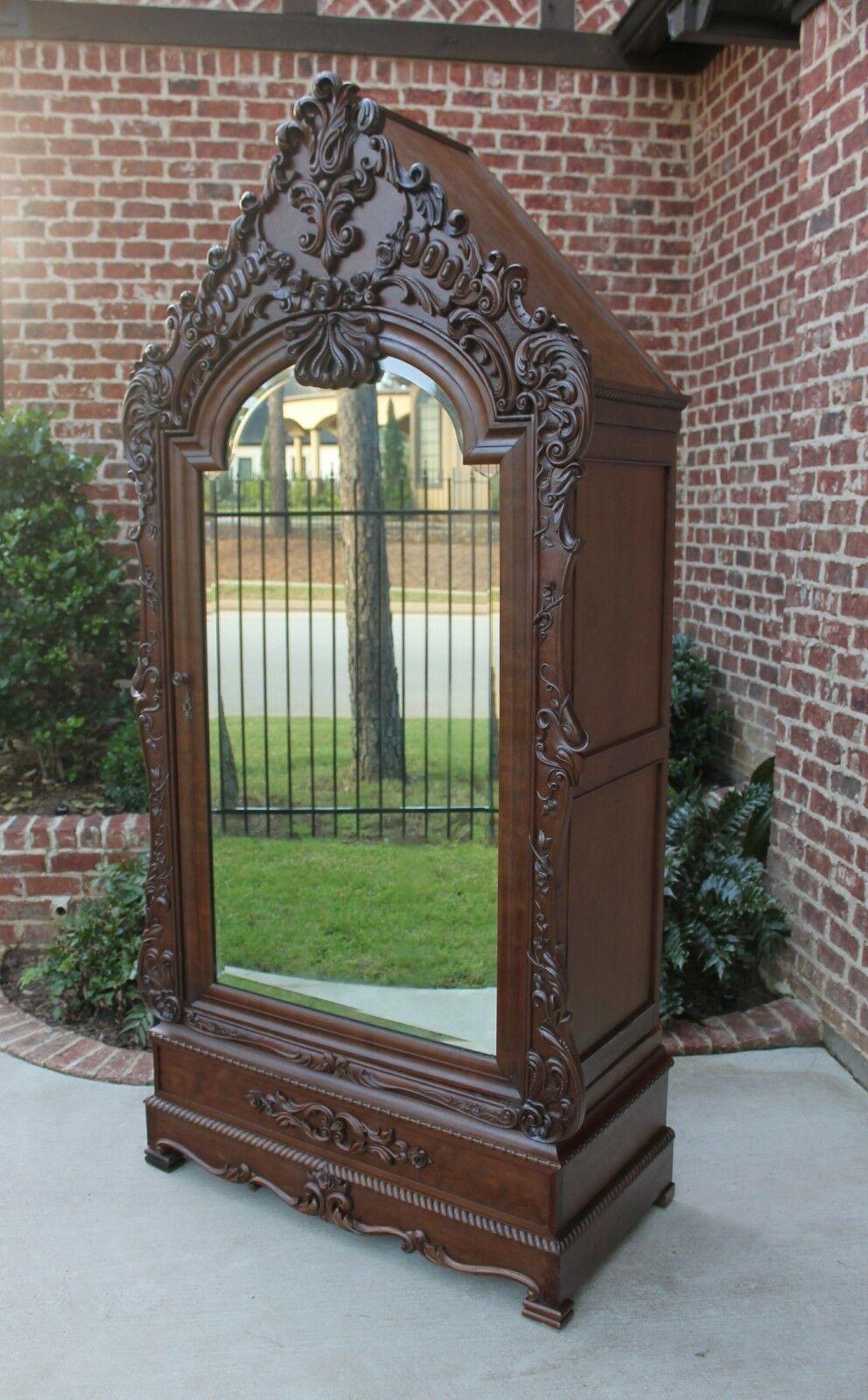 Stunning antique Italian walnut on oak rococo revival mirrored wardrobe, Armoire, linen closet/cabinet~~c. 1890s

 Beautifully carved gabled crown with ornate floral and foliate carvings

Rope trim with beveled mirrored door

Interior cabinet