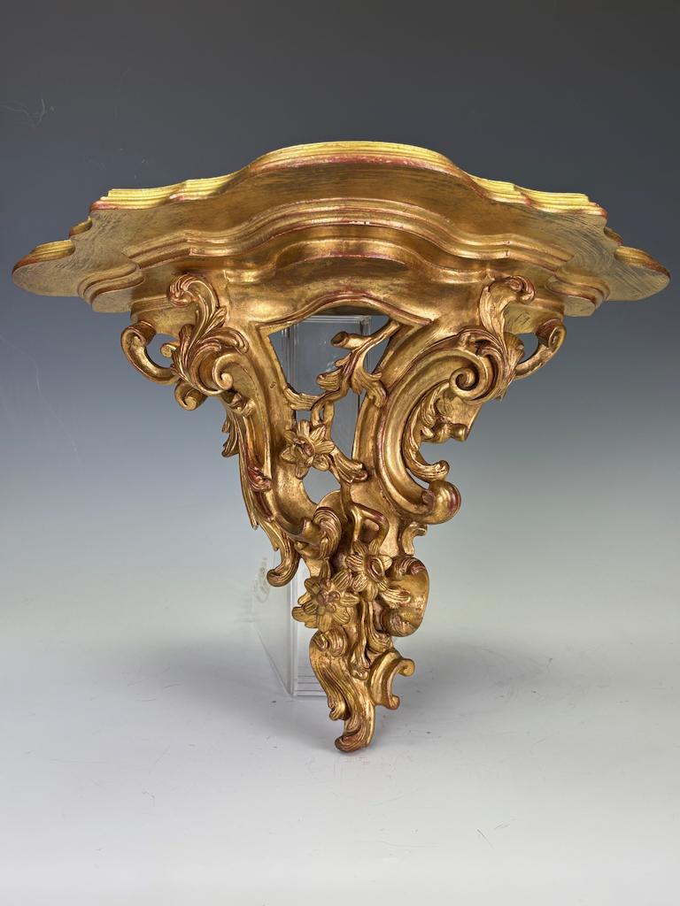 Antica mensola da parete in legno dorato in stile Rococò Revival italiano
Questa staffa da parete in legno dorato, in stile Rococò Revival, è stata realizzata in Italia all'inizio del XX secolo. Con un'ardita incisione di volute fogliacee, getti