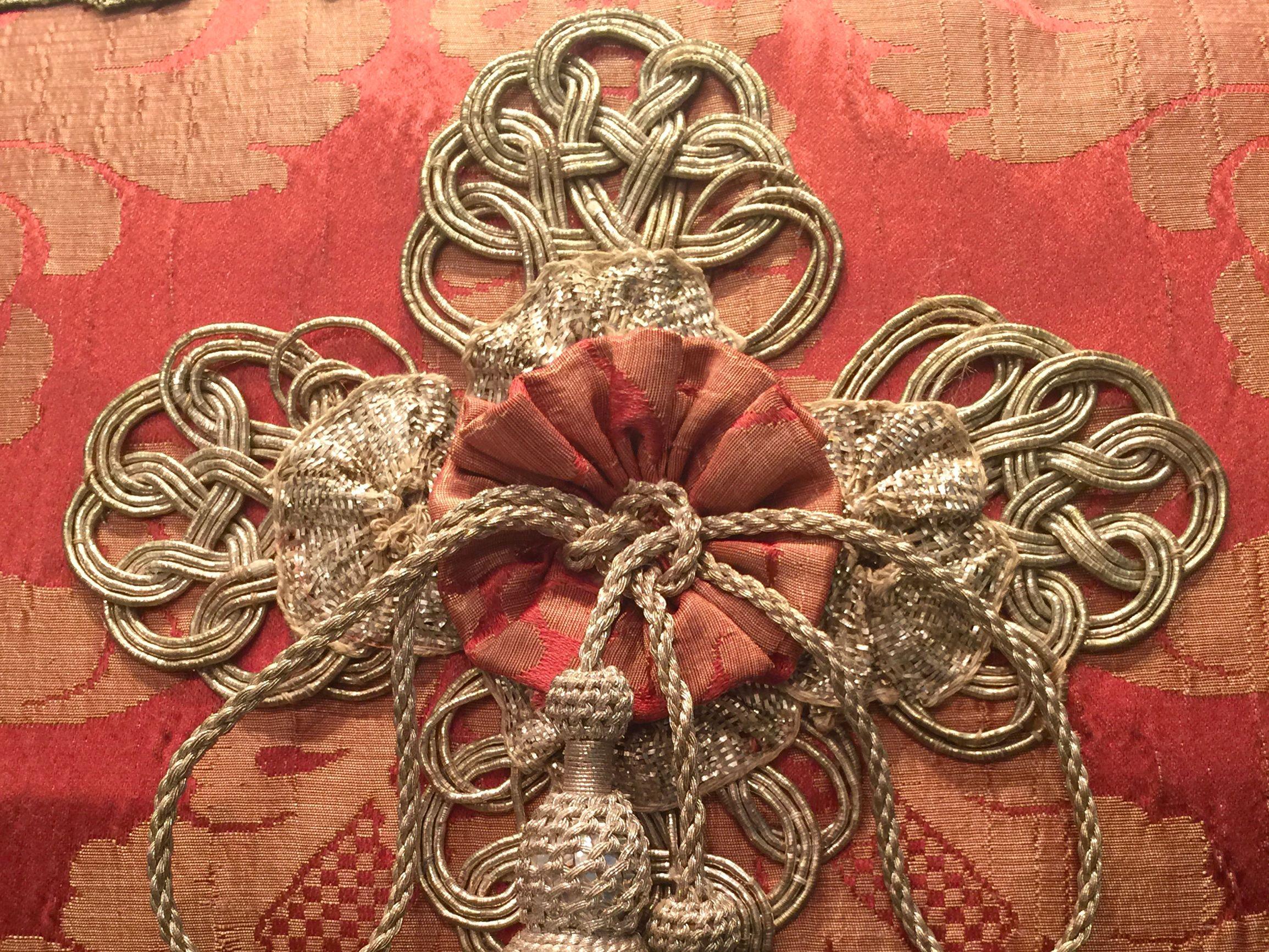18th century Italian Salmon Silk Damask is embellished by custom made central decor of antique Italian trim, rosettes (the silver ones have real silver thread woven throughout) and two 19th century Italian metal thread tassels. The two horizontal