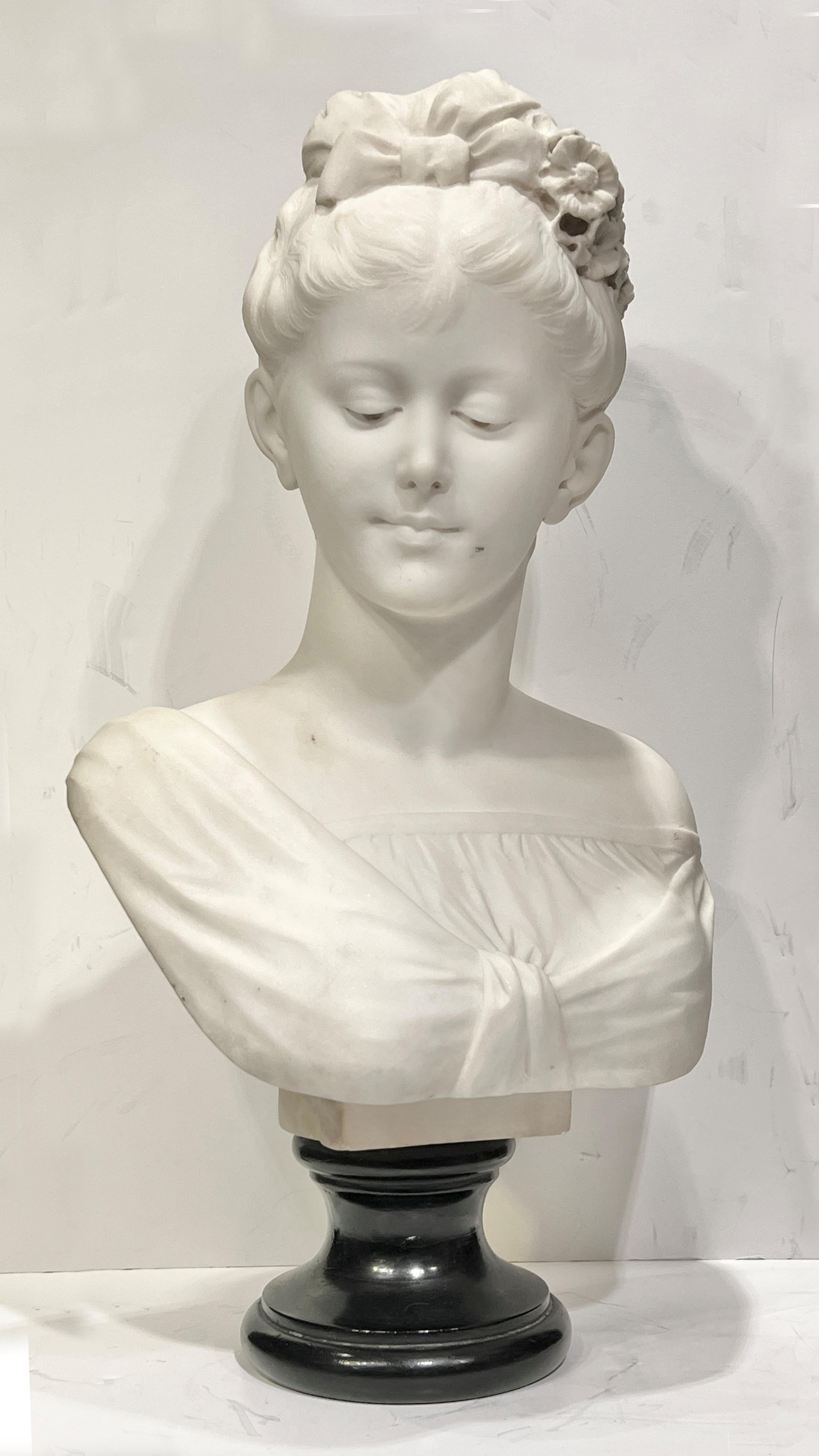 Buste ancien (19e siècle) en marbre blanc représentant une jeune femme avec des fleurs dans les cheveux, monté sur un socle rond en marbre noir.  23 x 12 1/2 x 7 pouces et 53 livres.  Apparemment non signé.