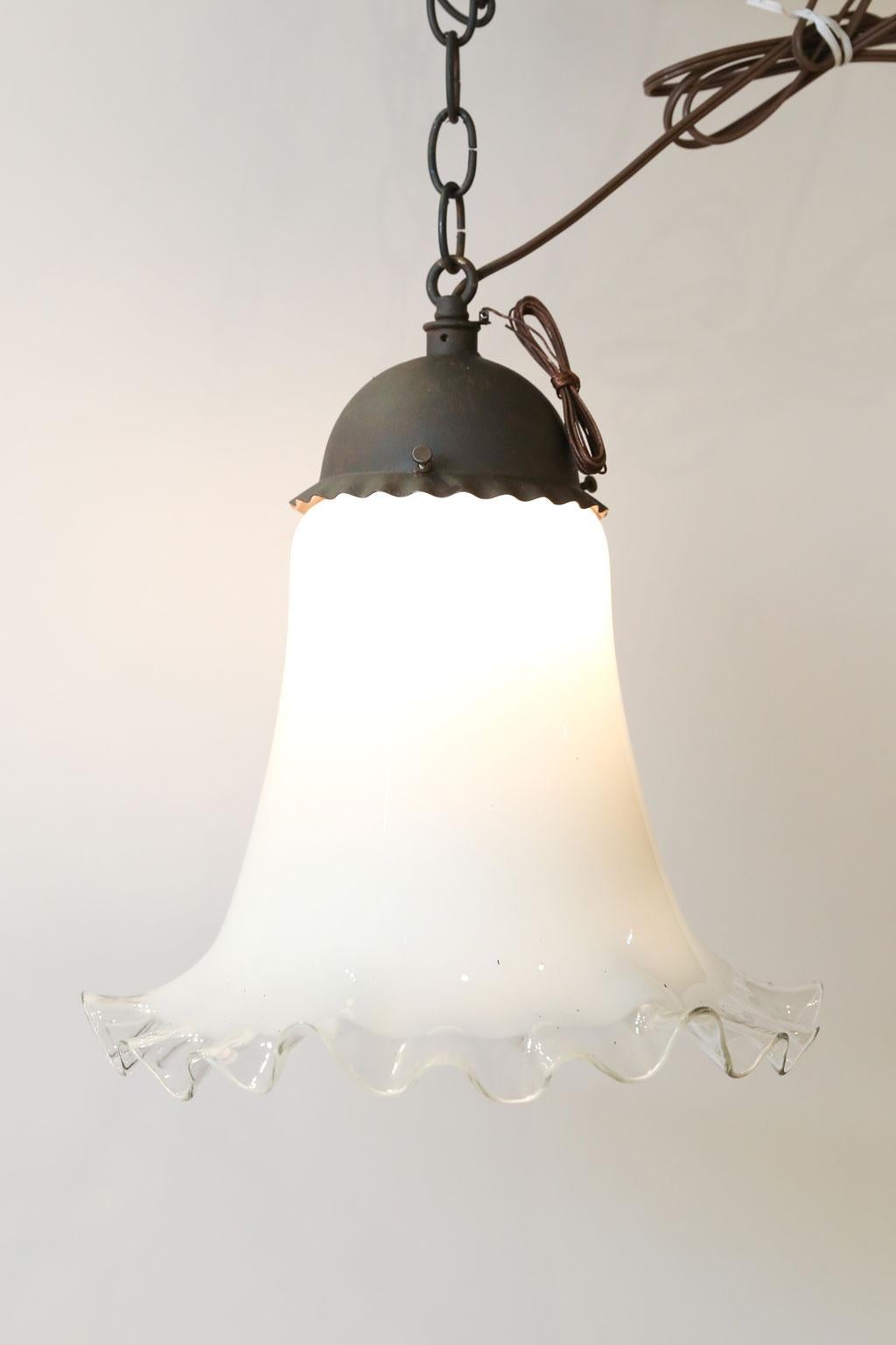Antique Italian single light: Nice old iron pendant fixture with antique milk glass bell-shape shade. White color of shade turns clear on a gradient towards the lower edge and is shaped with a ruffle. Newly wired for use within the USA. Includes