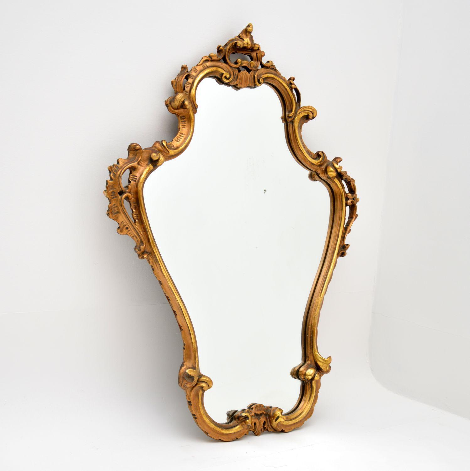 A stunning vintage gilt wood mirror in the antique Italian style. This dates from around the 1950’s.

It is well made and has a beautiful design. There is some minor wear to the frame and some very small areas of distress to the silvered backing