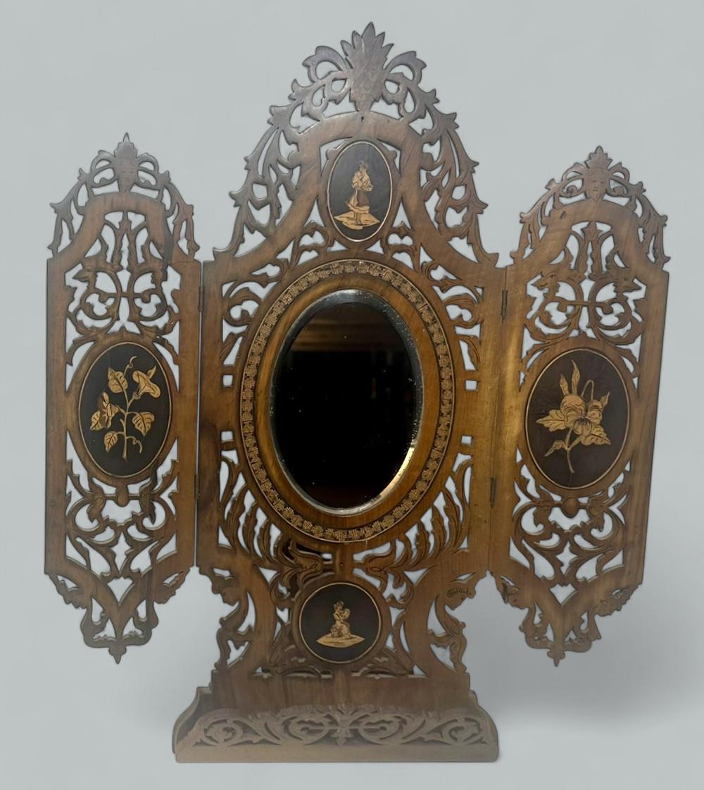 Un imponente espejo de pie plegable de nogal o madera de olivo de Sorrento, tallado a mano, de mediados a finales del siglo XIX. 

Los paneles calados con bisagras presentan magníficas incrustaciones de viñetas ovaladas figurativas italianas, que