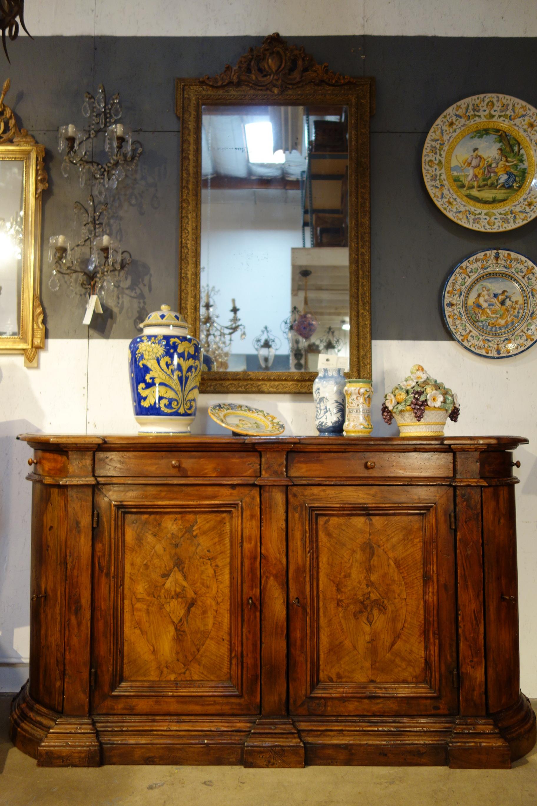 Custom sizing available with extraordinary Italian handcraft as exhibited in this 18th Century Style four-door and four-drawer credenza sideboard from Southern Italy, featuring thick Italian solid walnut planks, panels and trim with exceptional