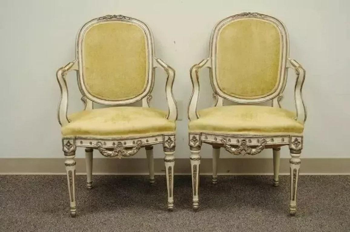 Anciennes chaises à accoudoirs en bois sculpté, peintes en couleur crème, de style vénitien - une paire. Cette pièce présente des accoudoirs à volutes, des dossiers à médaillons, des pieds cannelés et fuselés, un fronton et une traverse inférieure