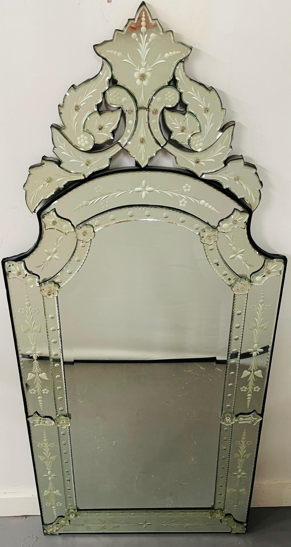 An exceptional antique Venetian etched glass wall mirror. The Venetian mirror features beautiful acanthus and floral etching design. The crown of the mirror is finely designed in acanthus pieces, adding style and elegance to this refined wall piece.