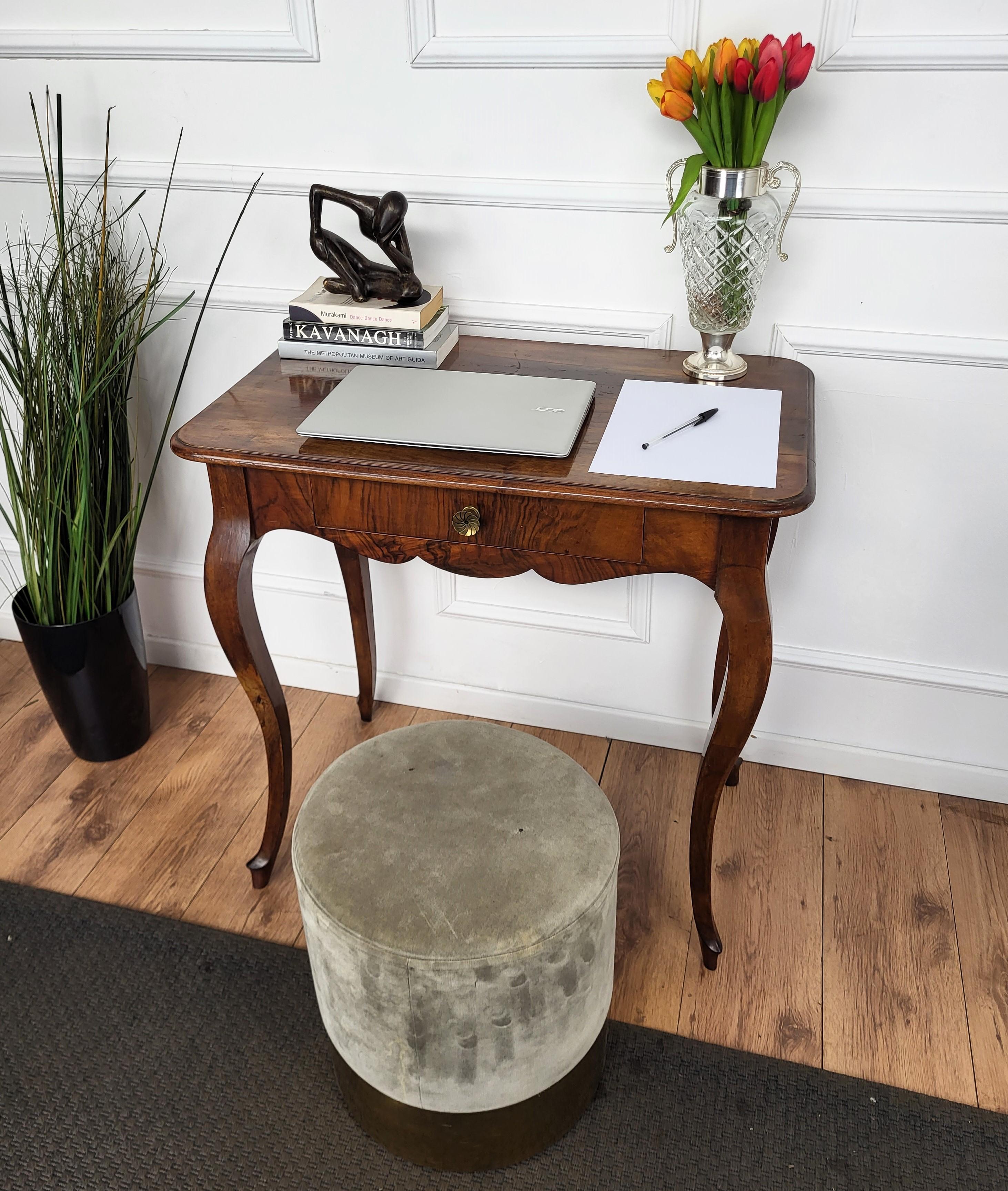 Beautiful antique Italian solid walnut side table with four beautiful walnut cabriole carved legs and detailed by the shaped corners, beveled top and central drawer with brass handle. This Italian walnut side table with the rich and beautiful wood,