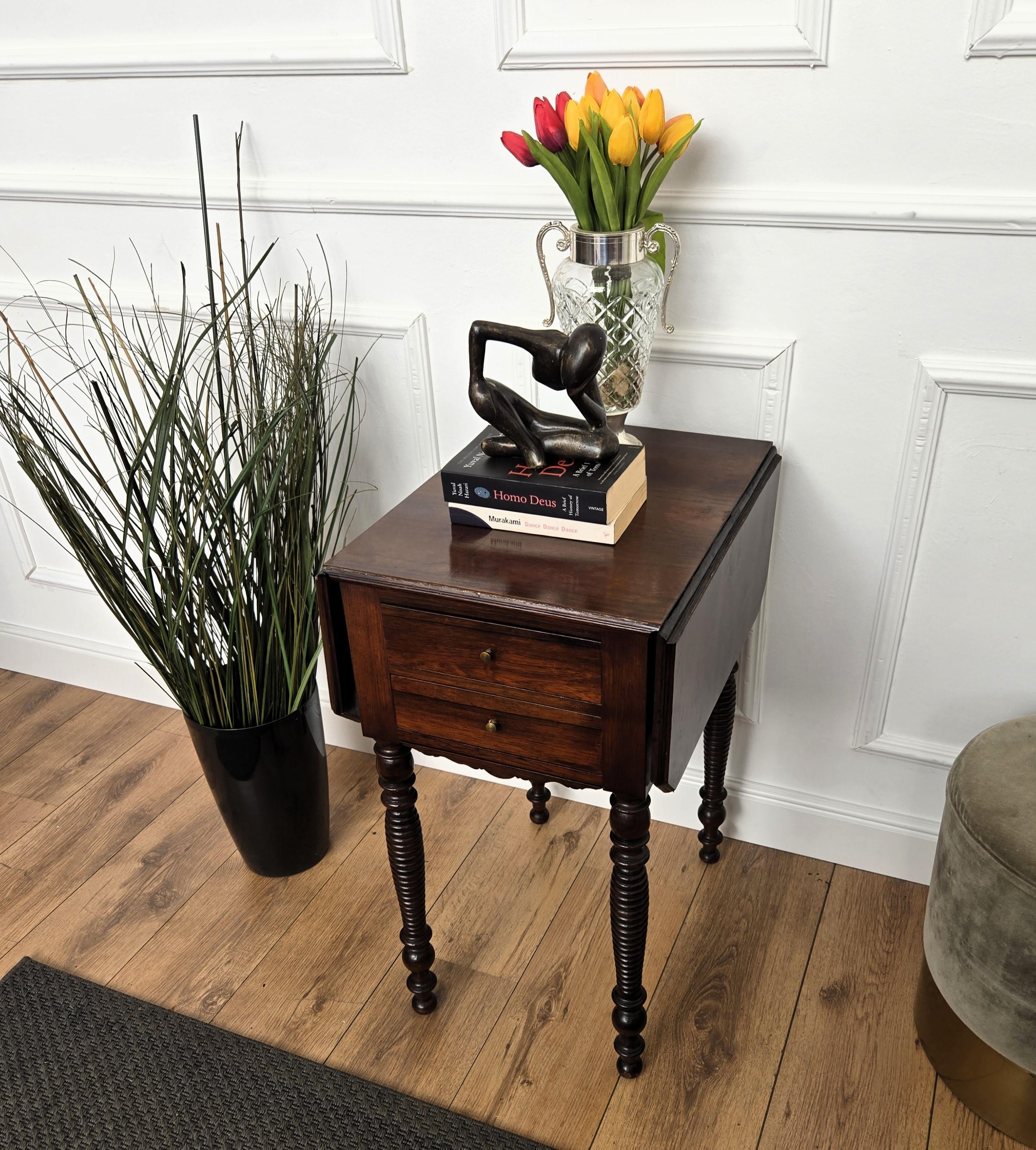Magnifique table d'appoint ou console italienne ancienne en noyer massif avec quatre beaux pieds sculptés en noyer, détaillés par le plateau pliant à feuilles tombantes biseautées. La partie avant comporte d'un côté 2 tiroirs et de l'autre une