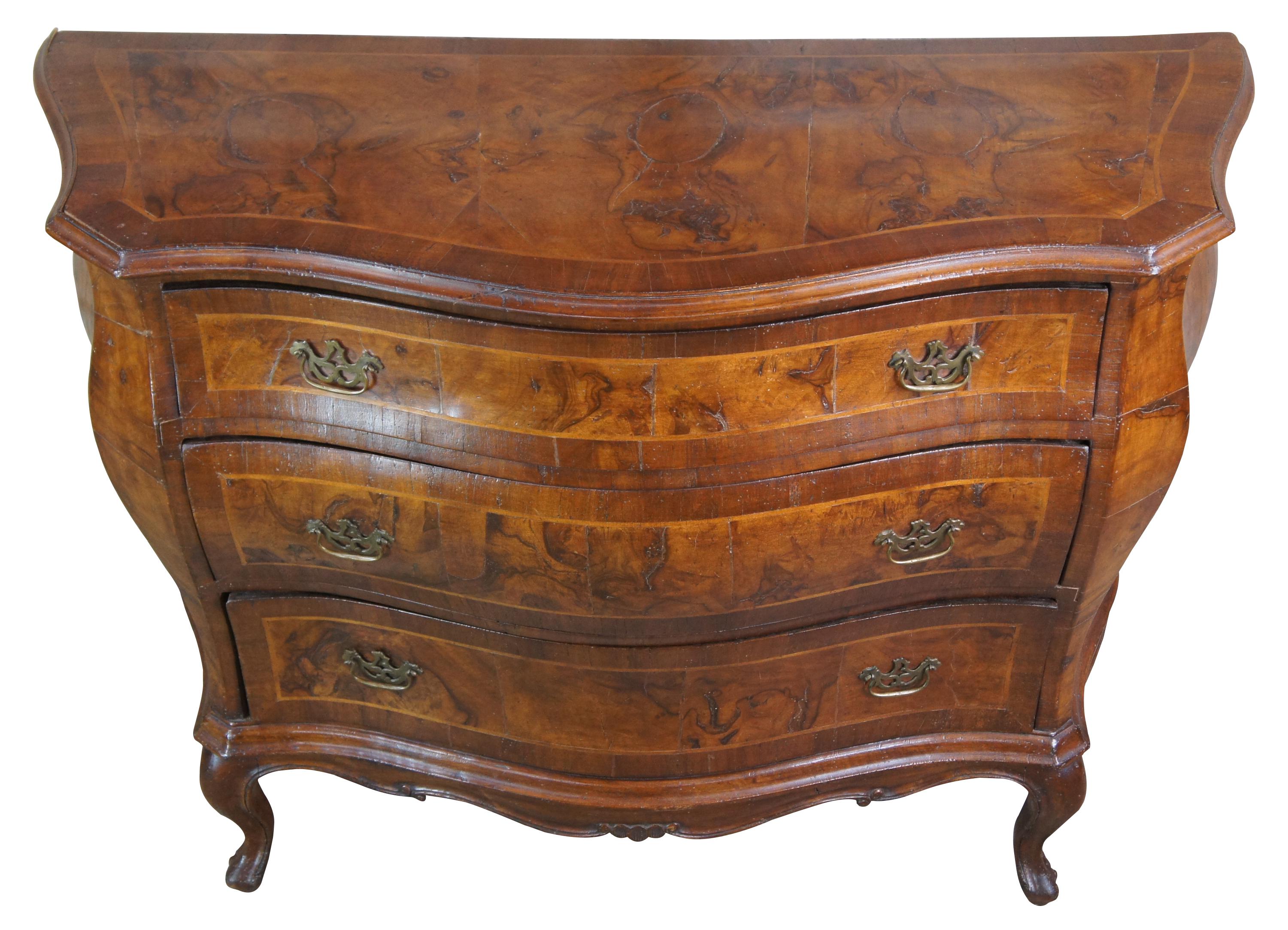 Antique Italian bombe, commode or chest, circa first half 19th century. Made of walnut and olive wood with naturaal distressing. Features serpentine demilune form with inlaid accents, brass hardware and hand cut nails. Measure: 47
