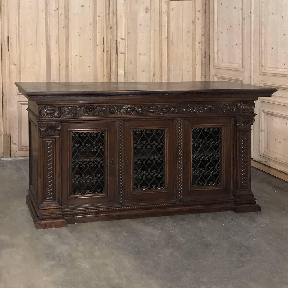 Antique Italian walnut Renaissance buffet/credenza, bookcase features stylish classically inspired architecture enhanced by hand-carved stylized foliate embellishments. Bold molding provides a framework, with carved pilasters appearing on the