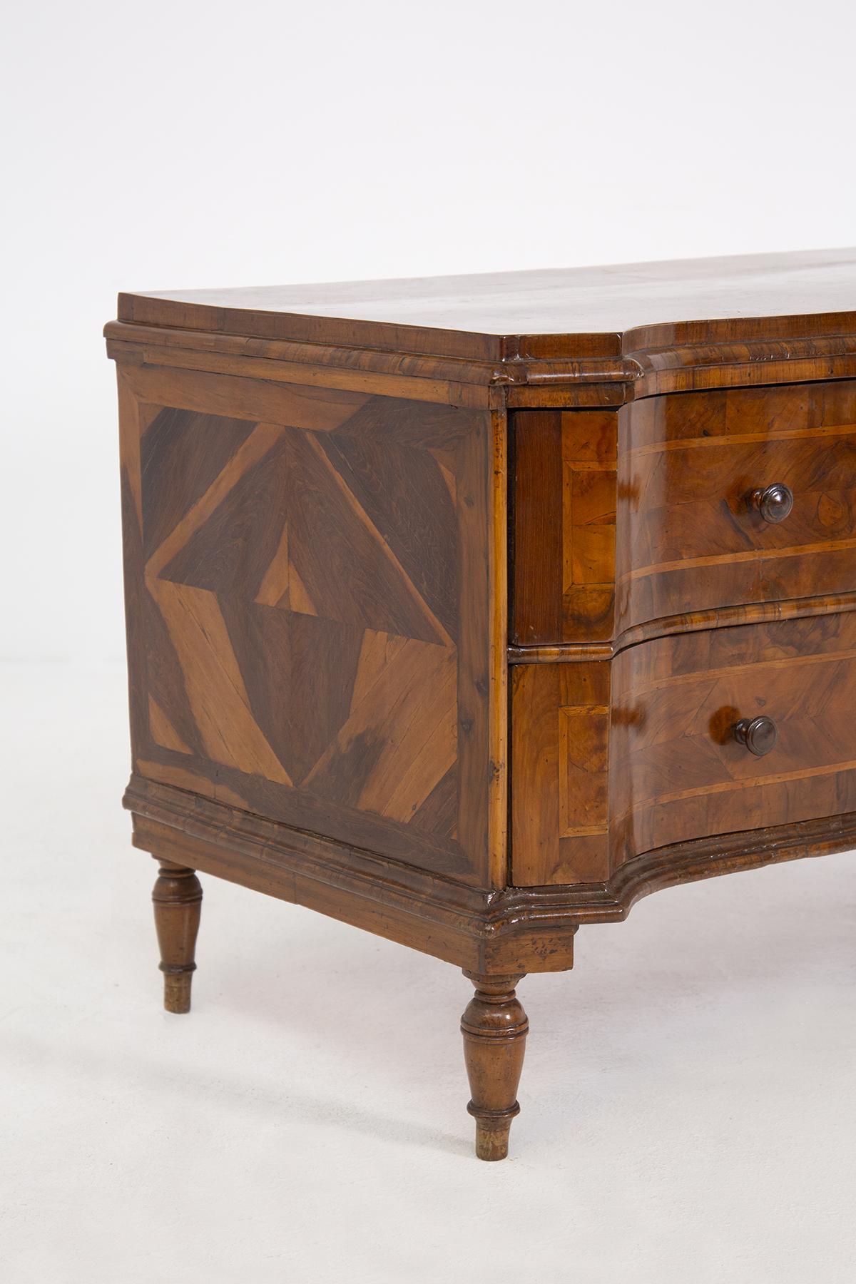 Refinada y antigua cómoda italiana de origen veneciano de alrededor de 1700. La cómoda está finamente elaborada por maestros carpinteros en madera de nogal, patinada por el tiempo. Encontramos una ingeniosa de uniones entre los distintos tipos de