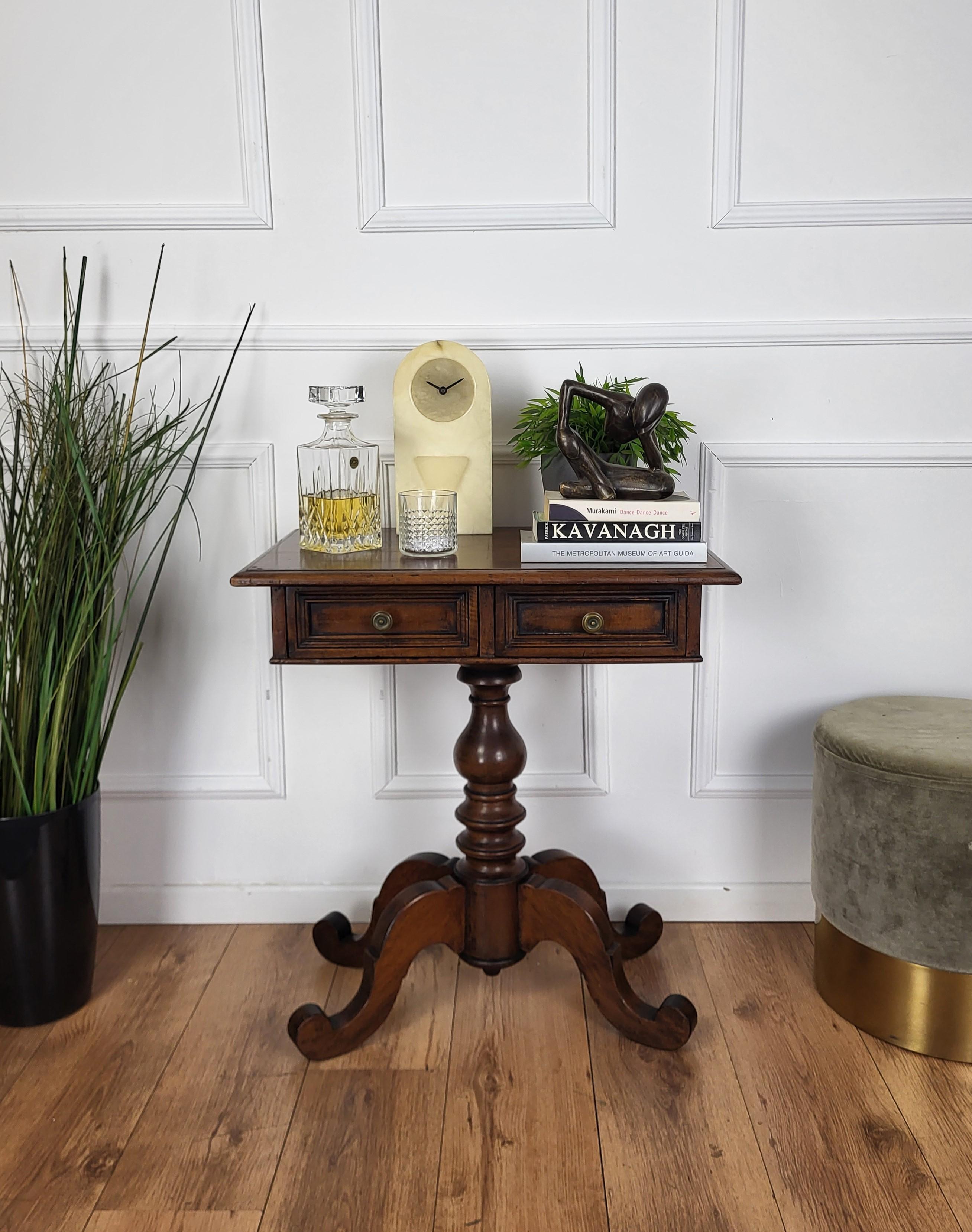 Beautiful and very elegant antique Italian solid walnut side table features an beveled top with two drawers and brass handles standing on a central beautifully crafted leg and classically carved feet. This Italian walnut side or coffee table with
