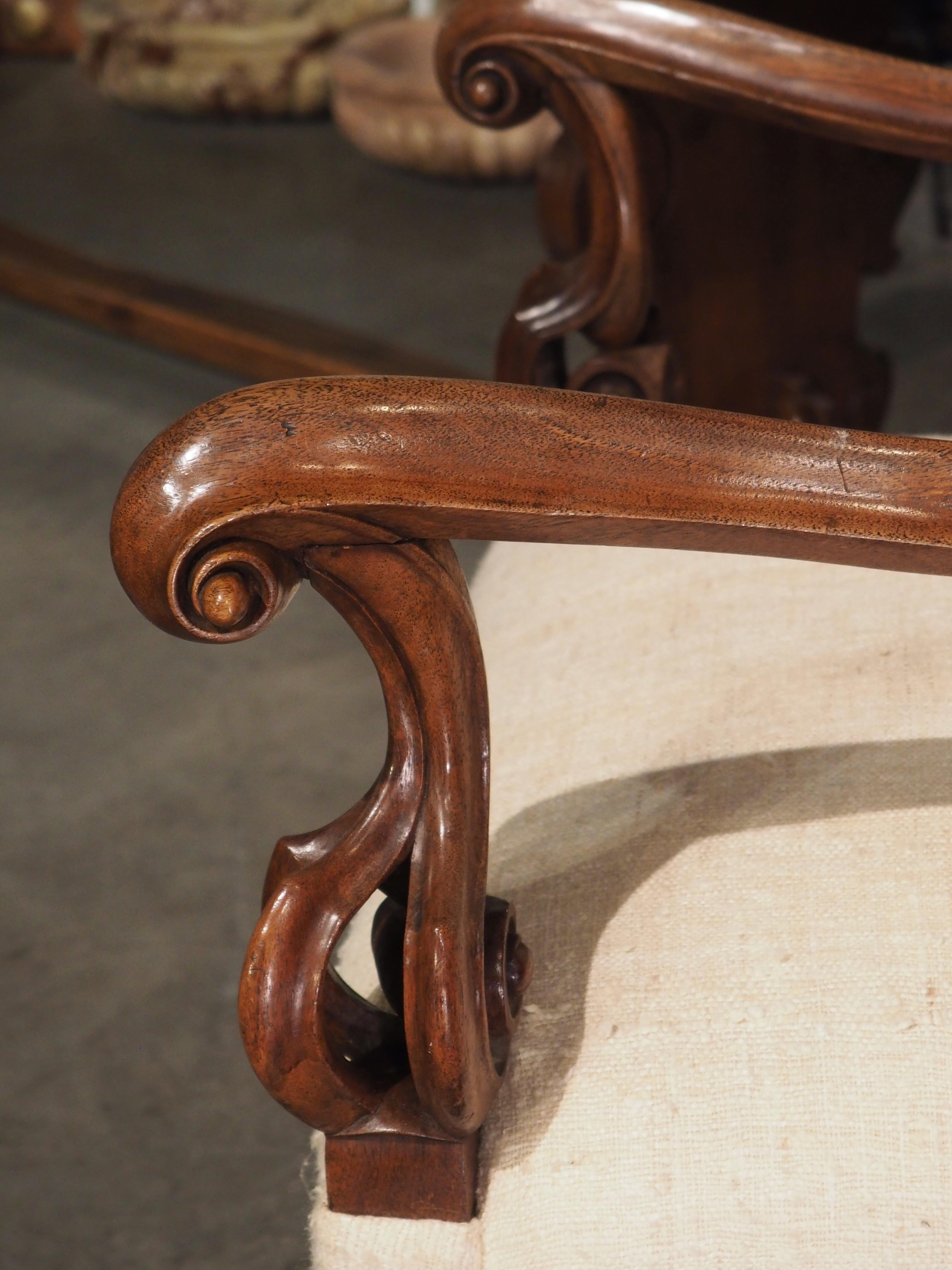 Dieser majestätische italienische Sessel mit Rohseidenpolsterung ist mit seinen hochdekorativen Motiven im Barockstil gehalten. Das Gestell aus Nussbaumholz, das um 1890 in Italien handgeschnitzt wurde, weist eine fantastische, reiche Patina in