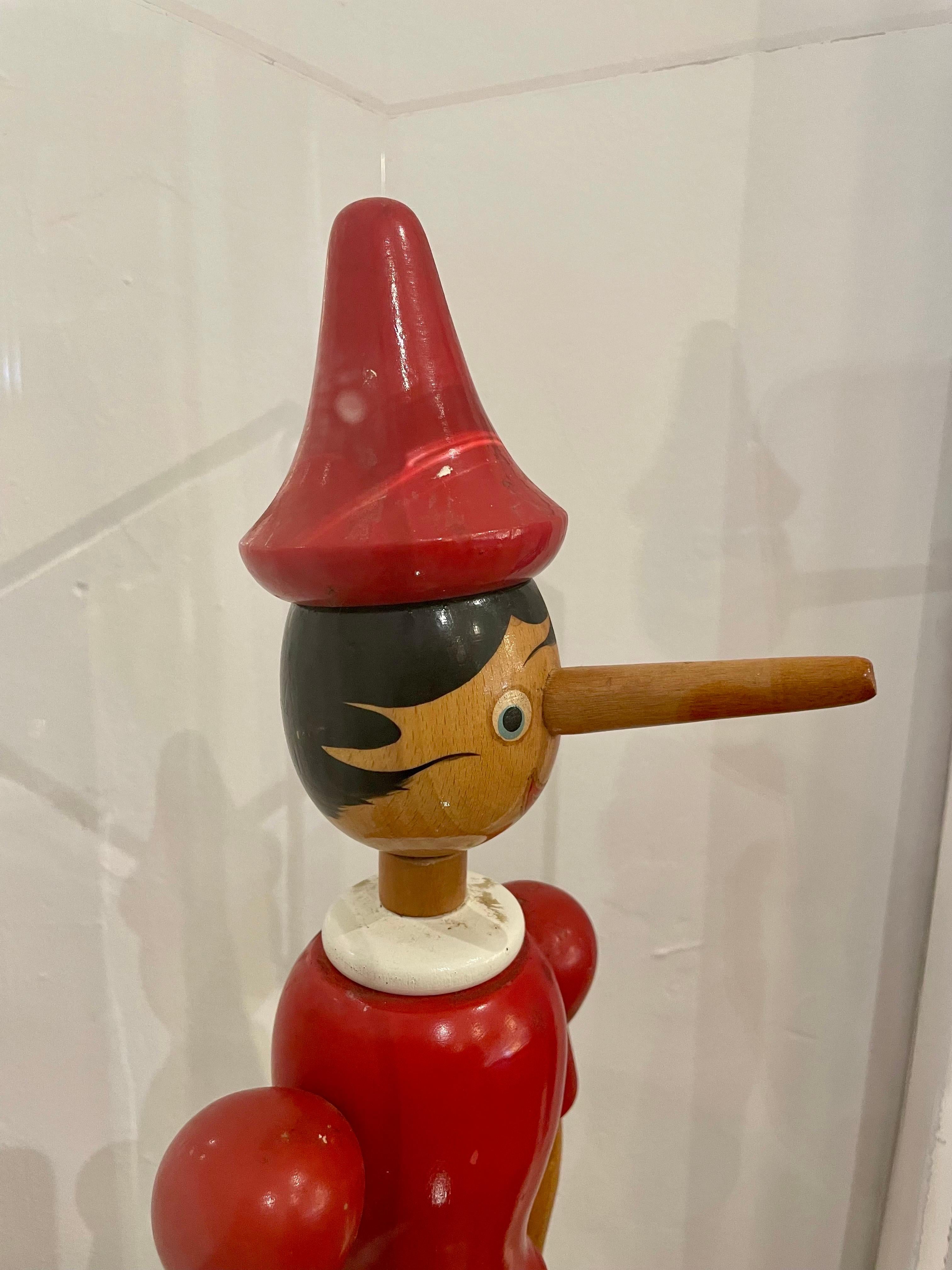 C'est un chef-d'œuvre en soi, un jouet en bois surdimensionné, sculpté et peint à la main, représentant Pinocchio, le jouet en bois qui est devenu un vrai garçon. Ce trésor du temps a été enfermé dans une boîte de présentation en acrylique faite sur