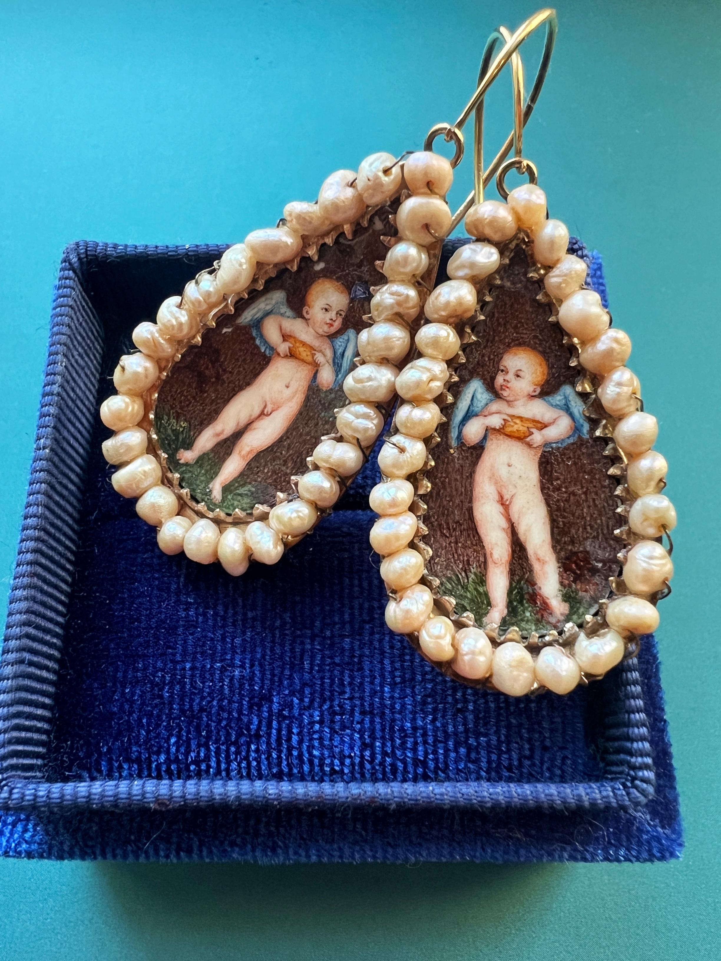 For sale a very rare pair of Italian antique 14k gold earrings from the late 18th century, featuring two large pear-shaped, enameled cherubs.

On each side, the cherub is depicted on foot, facing forwards and nude with blue color wings. He holds a