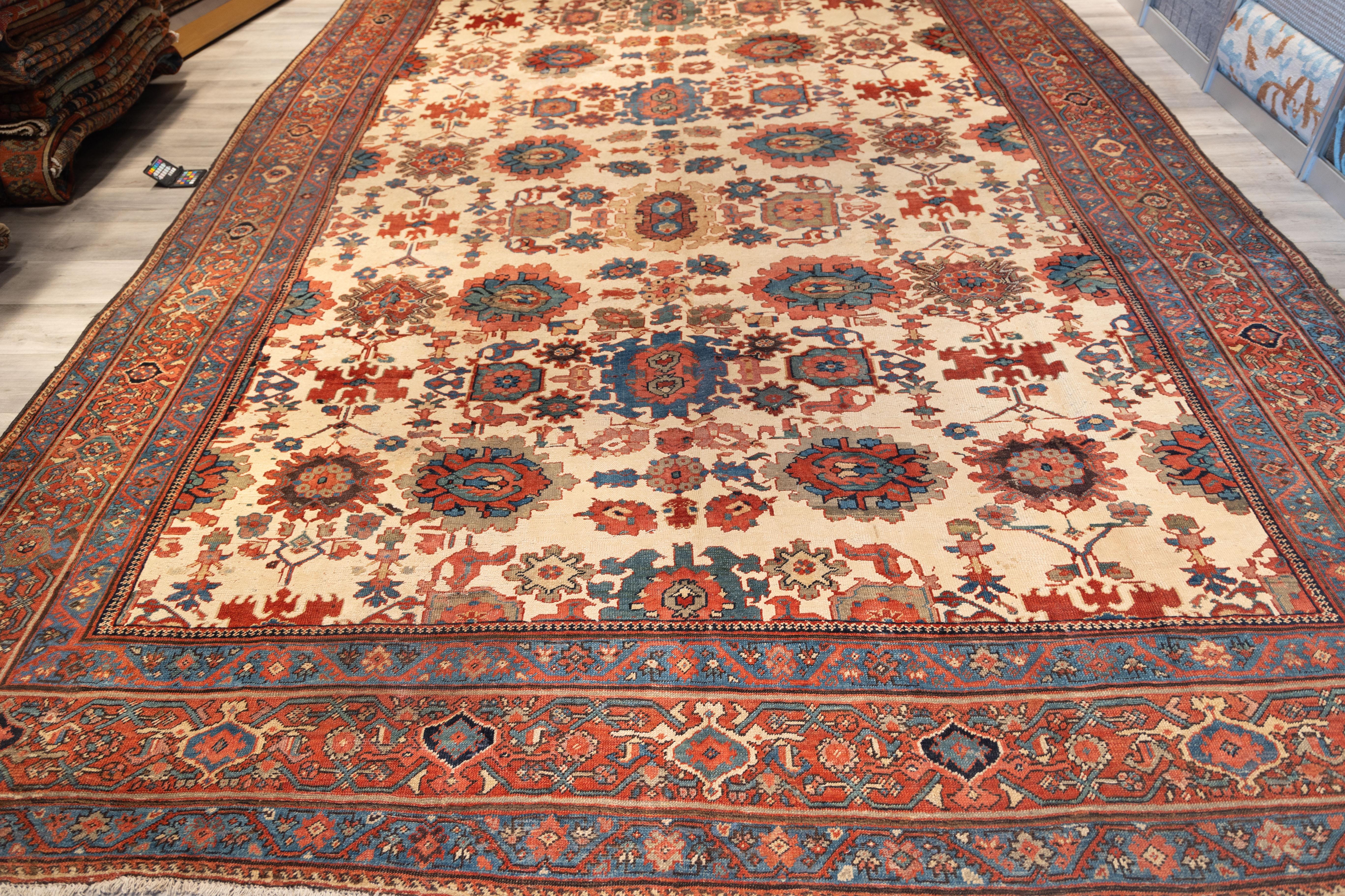 Bakhshayesh carpet is a superb example of Northwest Persian village weaving, characterized by its rich tribal spontaneity and archetypal design language. The field is a creamy ivory, setting a bold stage for large, stylized palmettes and geometric