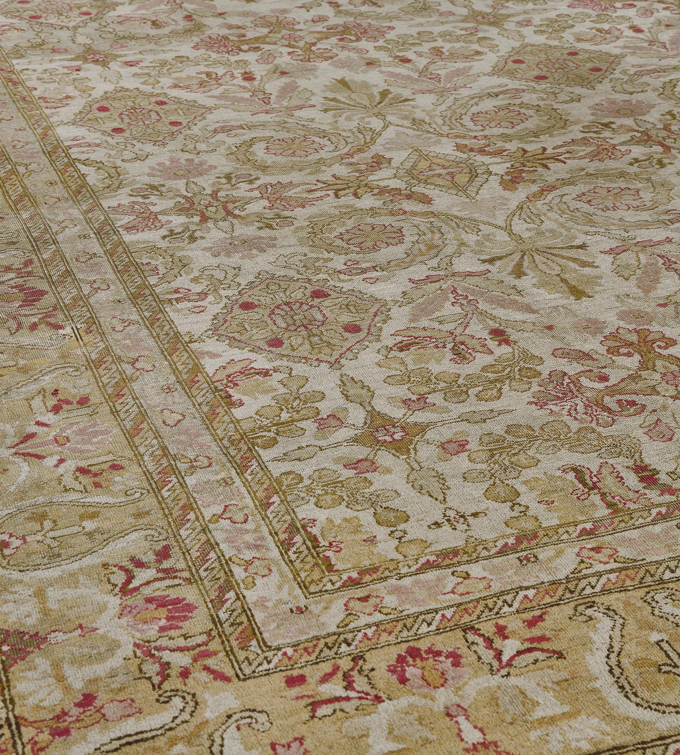 Questo antico tappeto indiano di Amritsar ha un campo avorio con un disegno complessivo di quattro file orizzontali di losanghe floreali verde pistacchio e rosa polveroso alternate a bande di losanghe di colore simile fiancheggiate da foglie