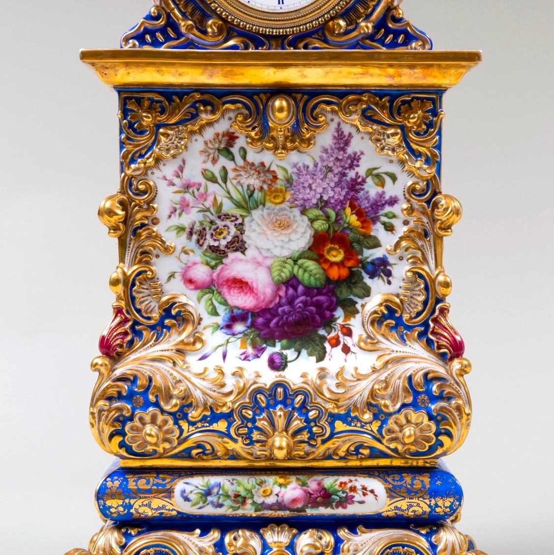 This stunning early 19th-century Jacob Petit porcelain clock showcases the pinnacle of French craftsmanship and design. The clock features a striking blue-ground base, lavishly adorned with hand-painted gilt decoration and an exquisite floral