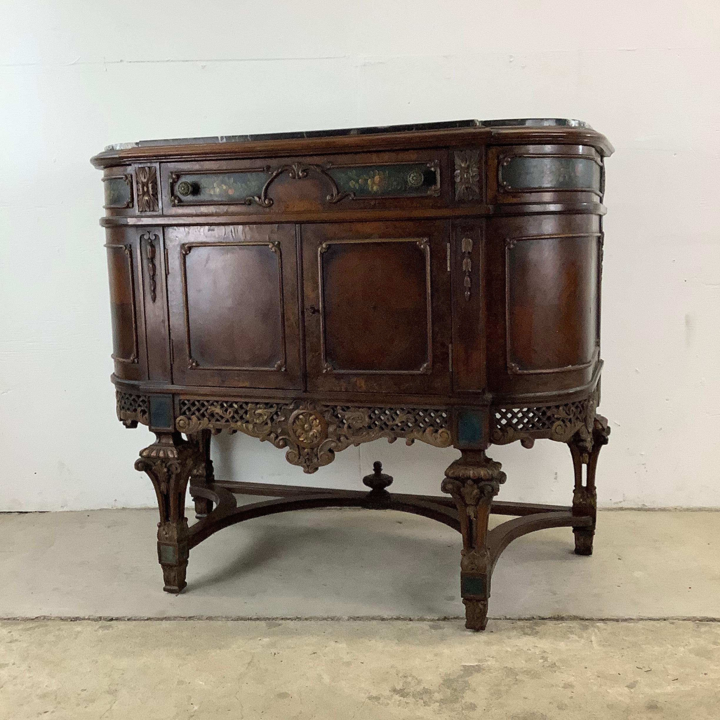 Embellish your space with this antique Jacobean-style marble top buffet sideboard. This exquisite piece, adorned with painted floral details and ornate wood carvings, is a testament to the opulence and craftsmanship of a bygone era of French