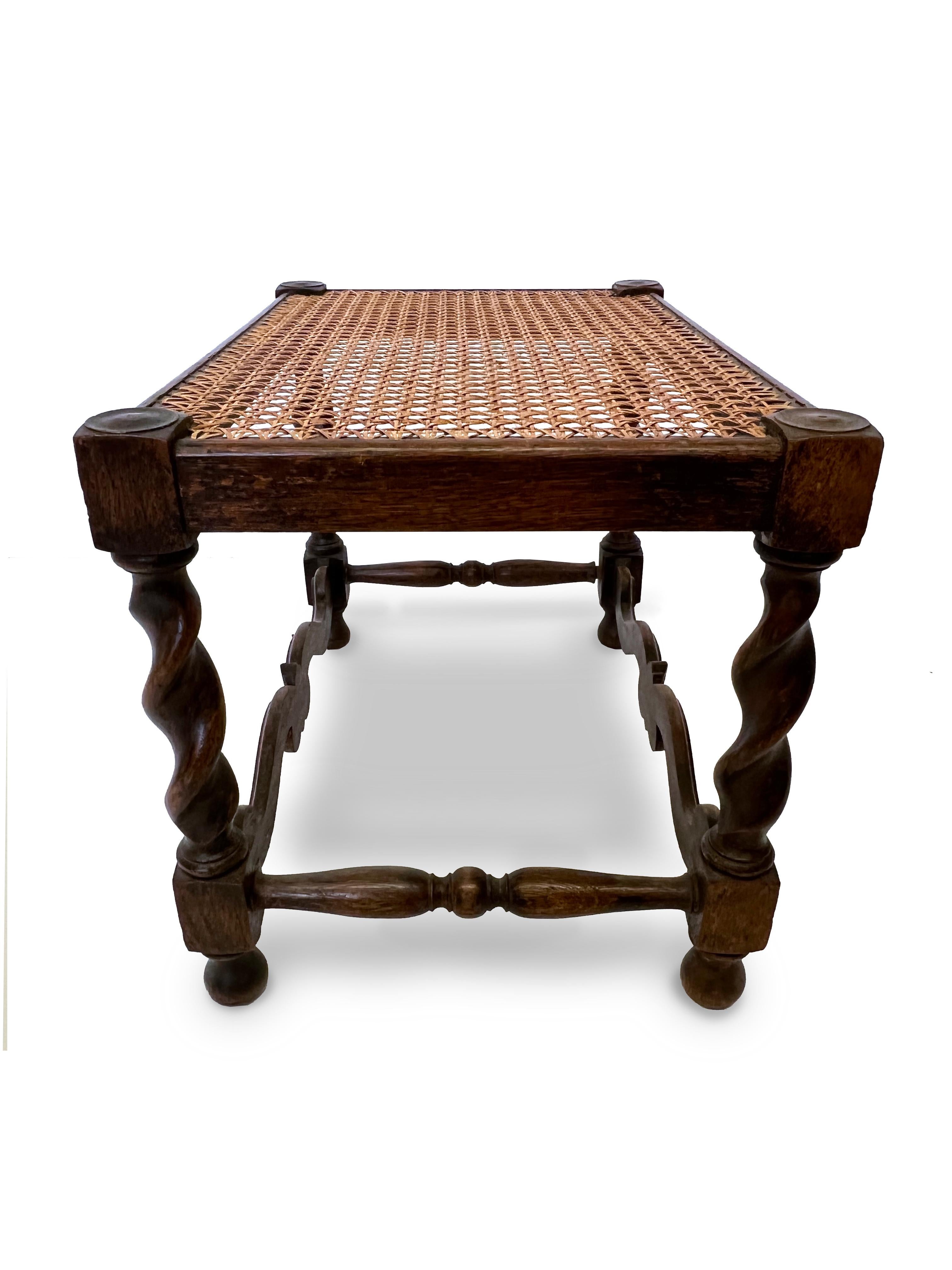 Antique Jacobean English hand carved oak barley twist stool with cane top. A perfect and unique antique stool or bench. In great conditons with original cane top and pear like shaped feet. circa 1900

Property from esteemed interior designer Juan