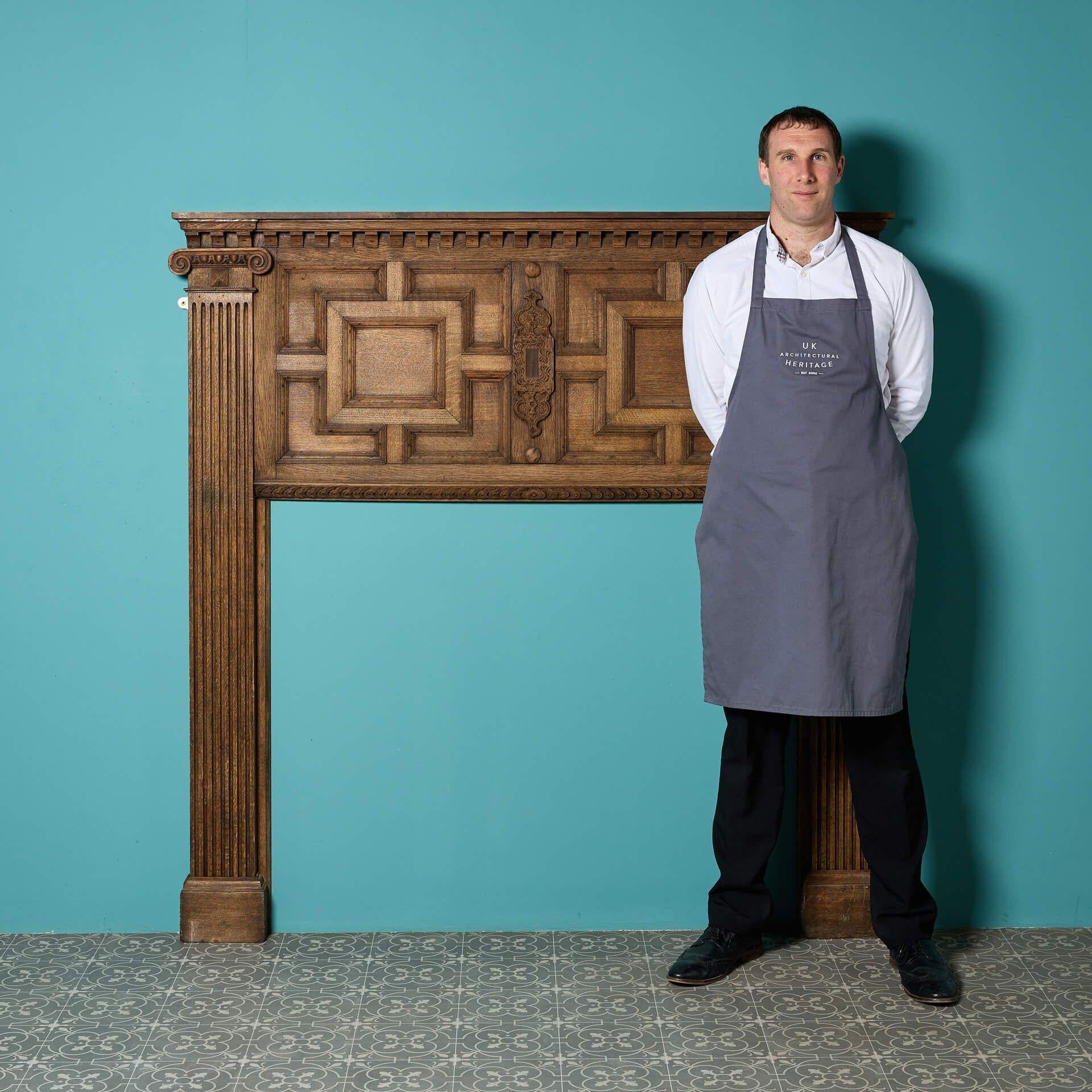 A sophisticated antique Jacobean wooden fireplace with a usual panelled geometric style frieze.

With a striking profile, slim shelfs supported on dentils, and fluted columned jambs, this handsome antique fireplace is a superb addition to period and