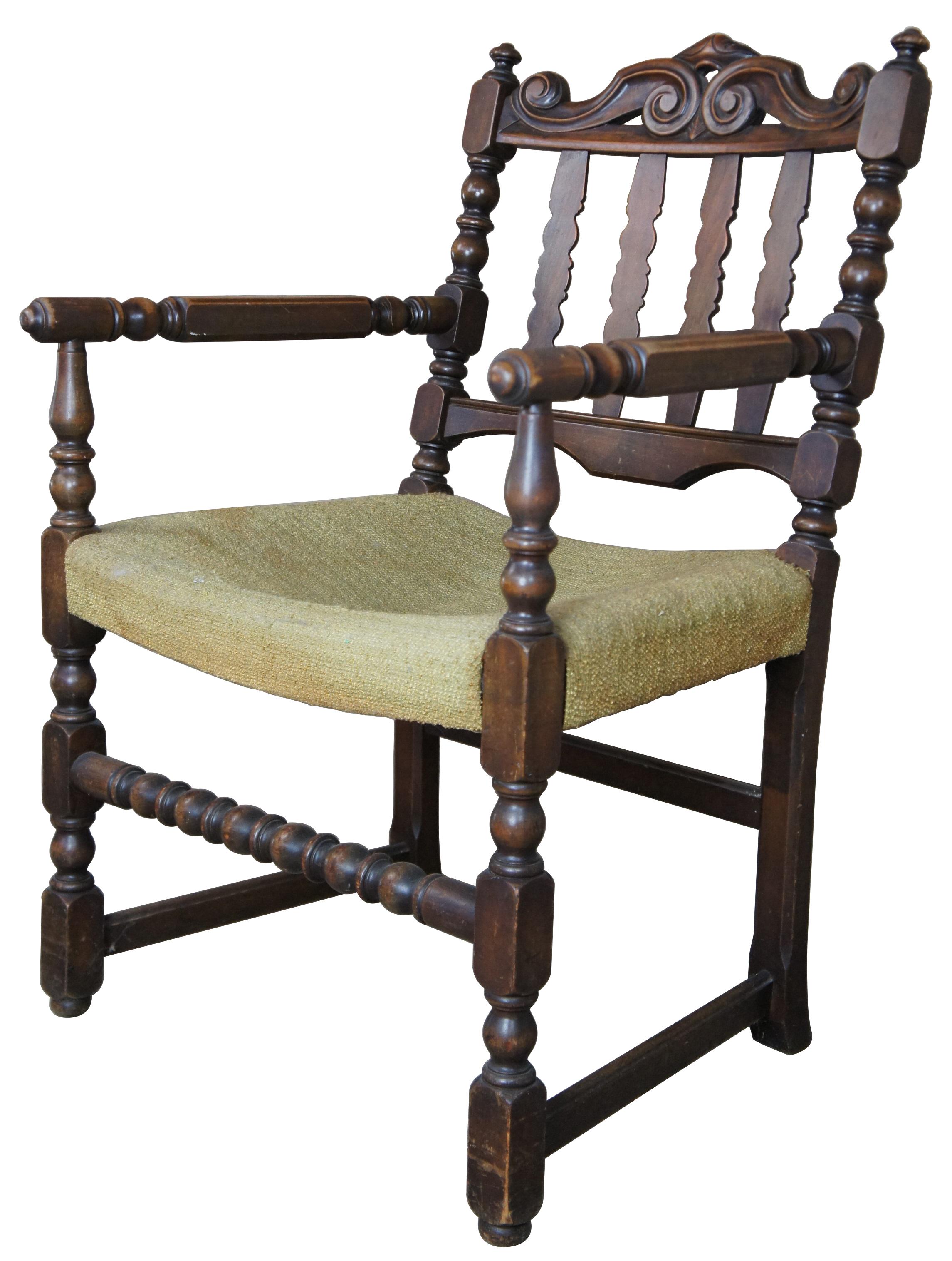 Antique Jacobean arm chair. Features a scrolled serpentine rail over slat back. Features square supports with spool carvings. Measure: 36