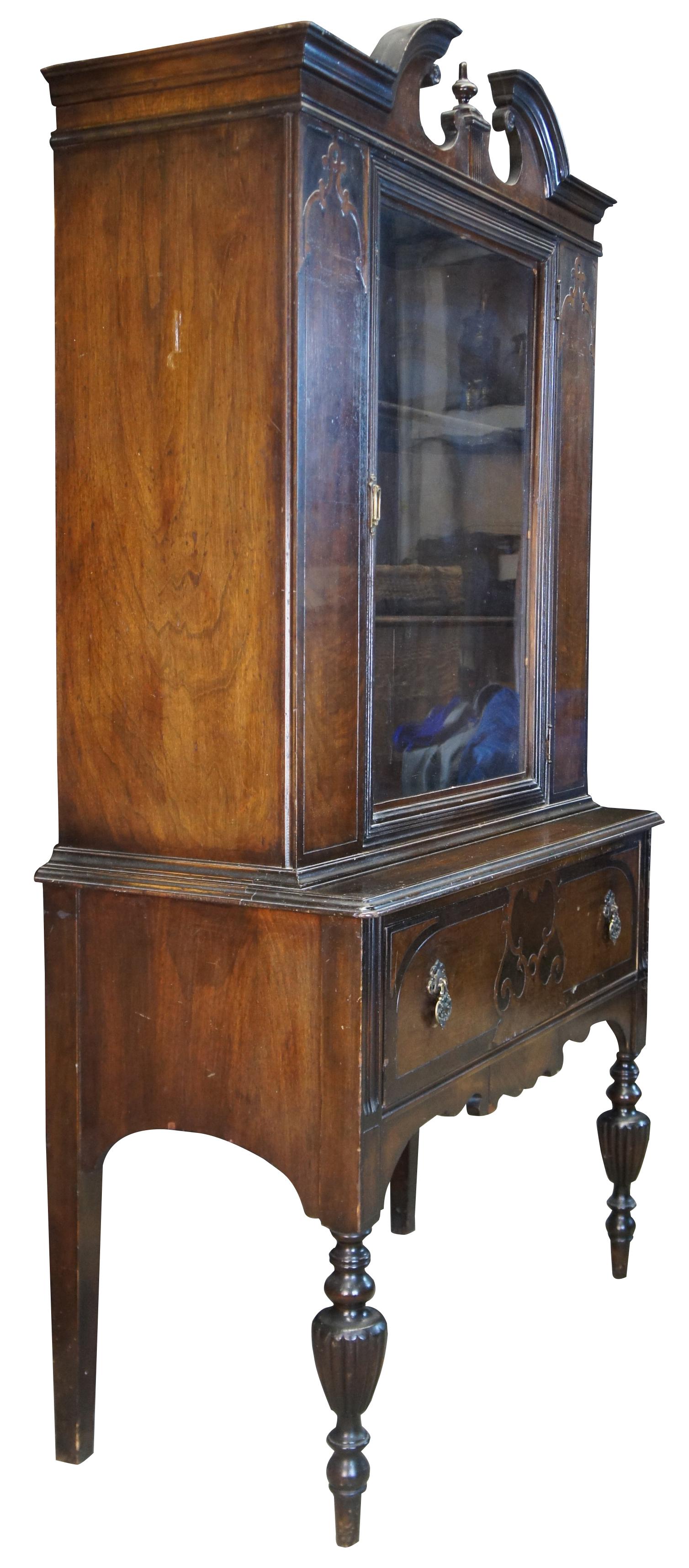 Jacobean revival china hutch, circa 1940s. Made from walnut with a burled front panels. Features two shelves concealed by a large central door over dovetailed silverware drawer. Includes an open pediment crown and serpentine lower apron. The cabinet