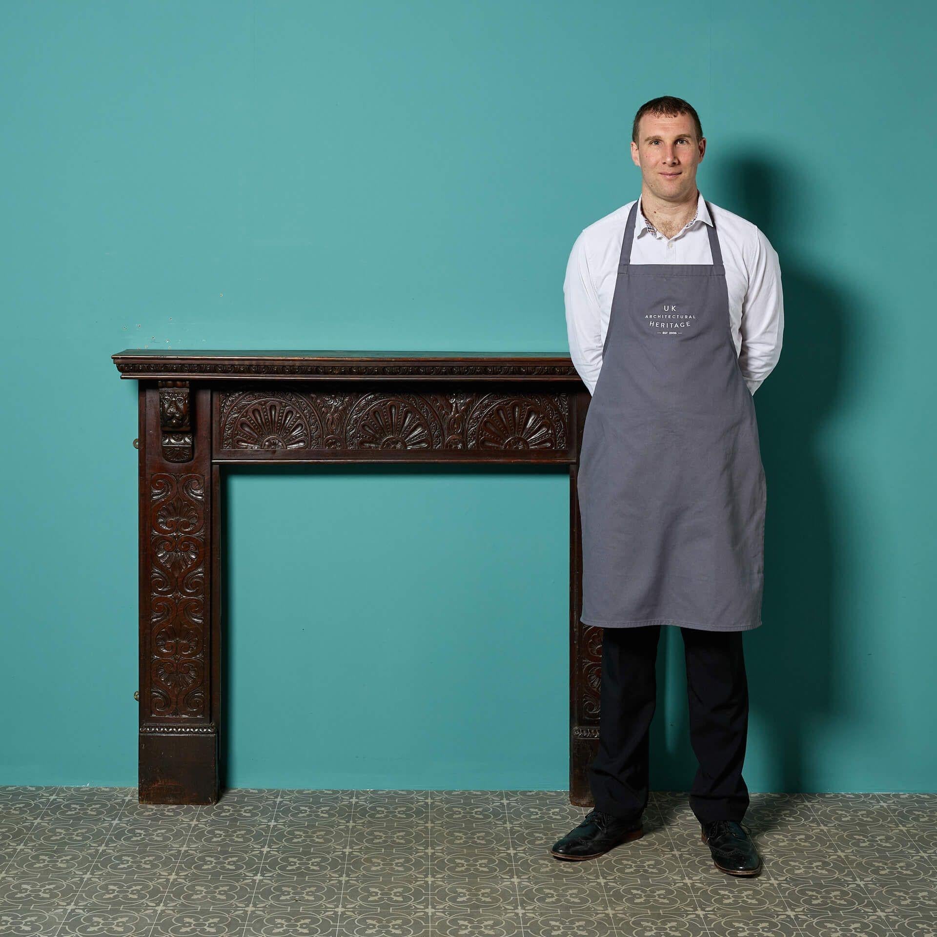 A late Victorian antique Jacobean style carved oak fire mantel, hand crafted with ornate carvings throughout and lion head corbels to the end blocks. This stylish antique fire surround is a handsome addition to interiors traditional and contemporary