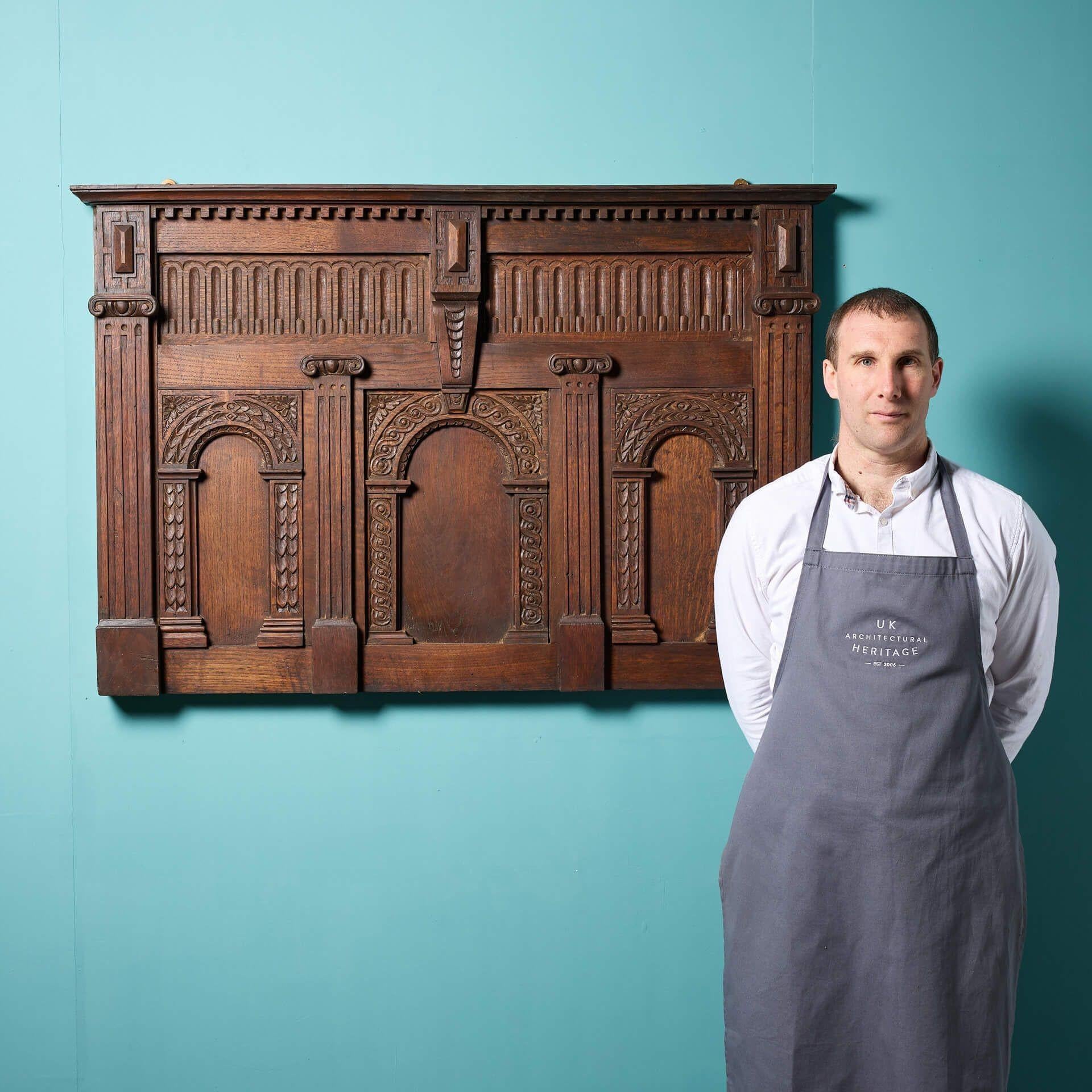Gran e impresionante panel decorativo de roble para colgar en la pared, de finales del siglo XIX, de estilo jacobino, tallado a mano con tres arcos ornamentados, columnas neoclásicas, dentils y motivos geométricos en toda la superficie.

Este panel
