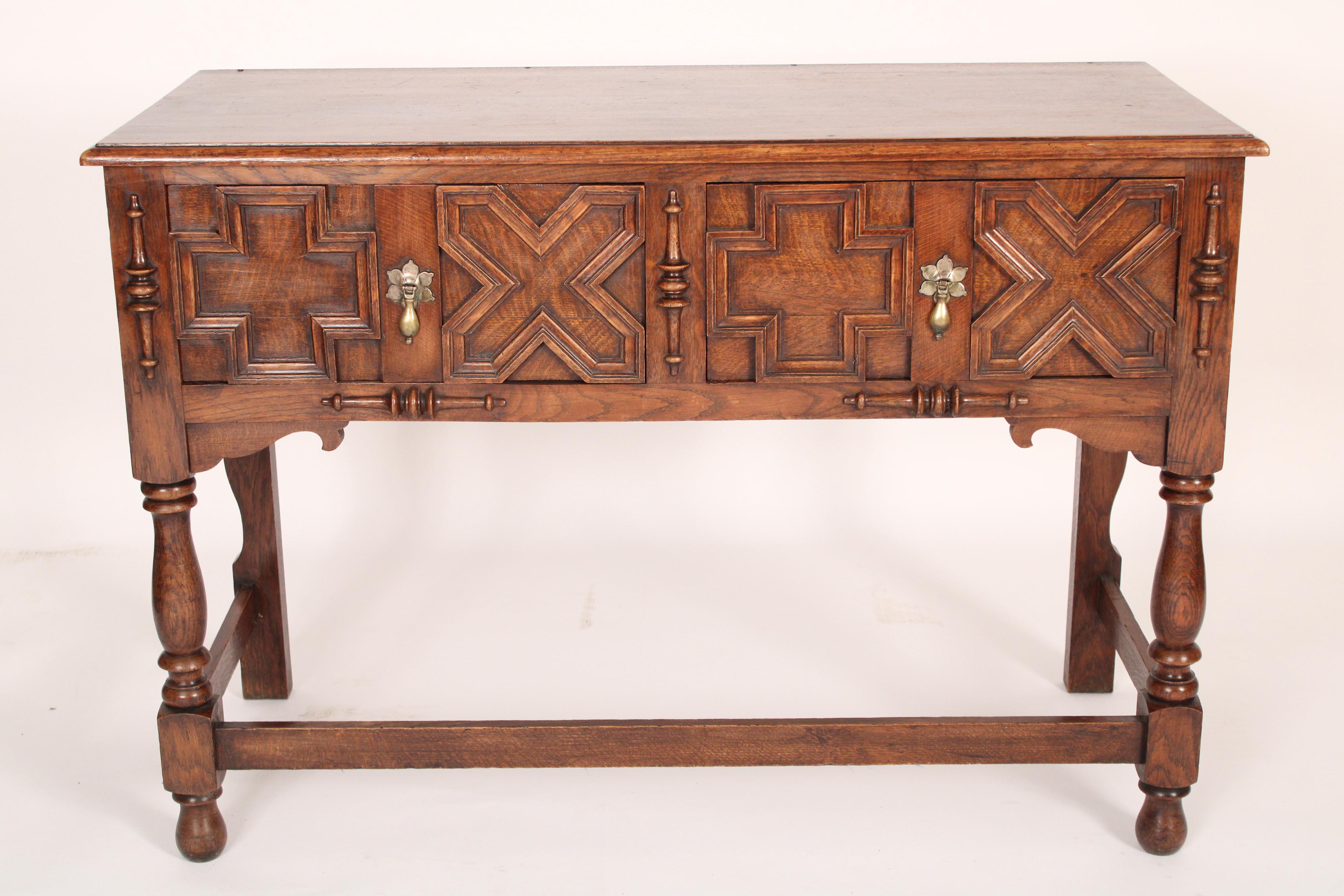 English oak Jacobean style sideboard / server/ console table, circa 1910. With a rectangular thumb molded top, two frieze drawers with geometric designed moldings and split and applied turnings, brass tear drop drawer pulls, turned legs joined by