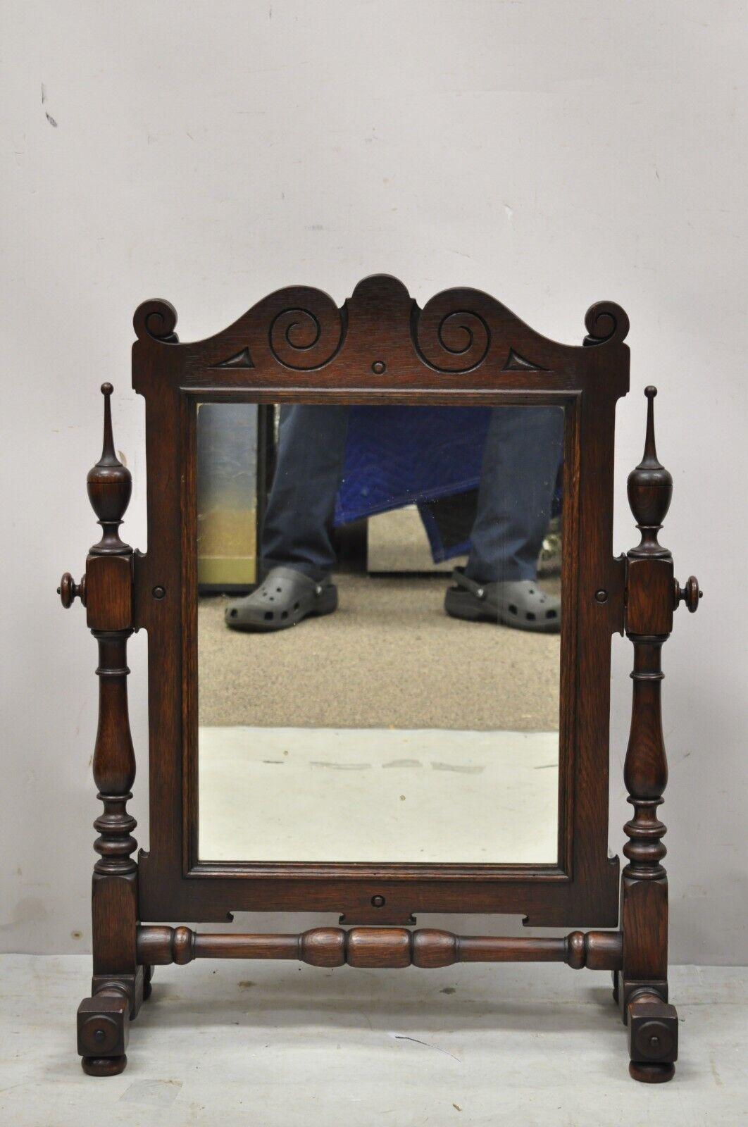 Antique Jacobean Style Oak Wood Pivoting Dresser Shaving Mirror. Item features carved wood finials, pivoting mirror, solid wood frame, beautiful wood grain, great style and form. Circa Early to Mid 1900s. Measurements: 29.25