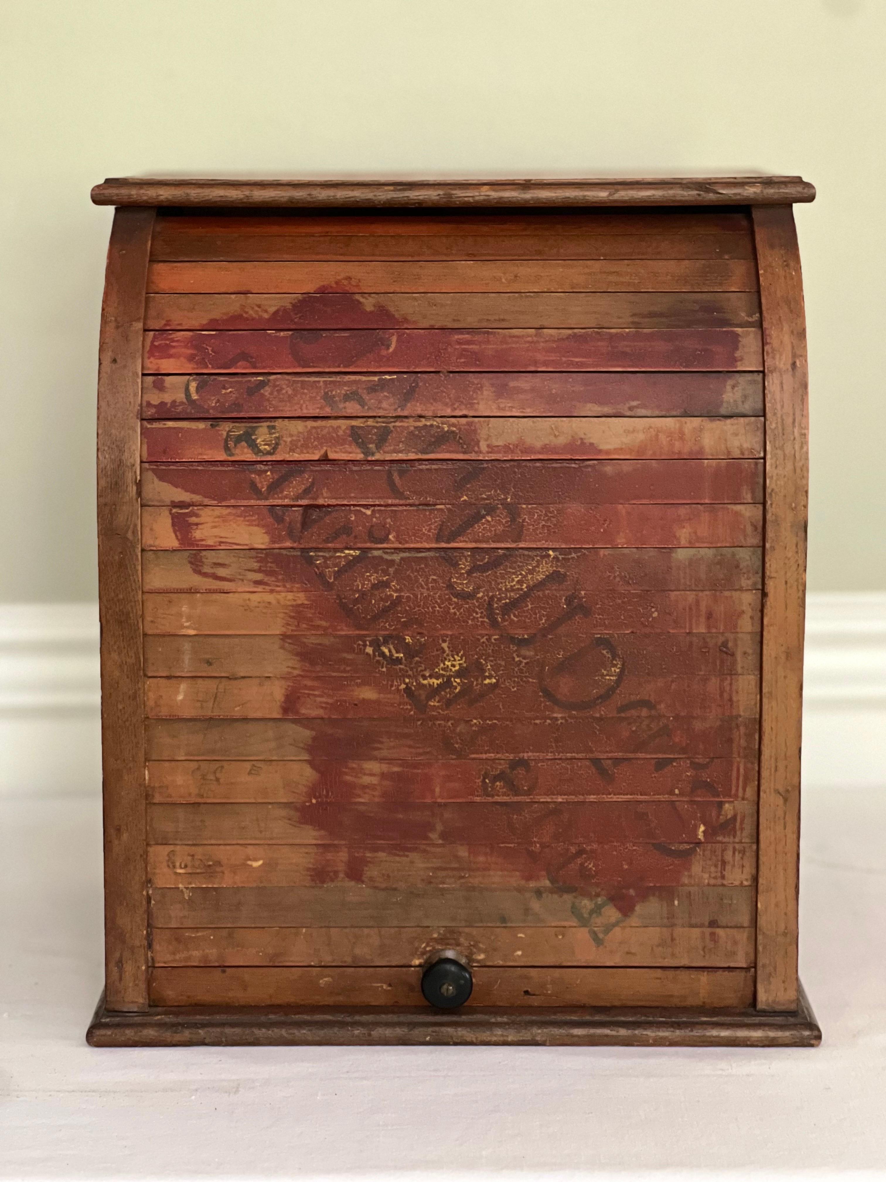 Authentic roll top general store countertop display cabinet for Jacquot's Genuine French blacking polish or dye, c. 1900. It features a tambour style cylinder front enclosing three shelves with original, fitted removable liners. This charming piece