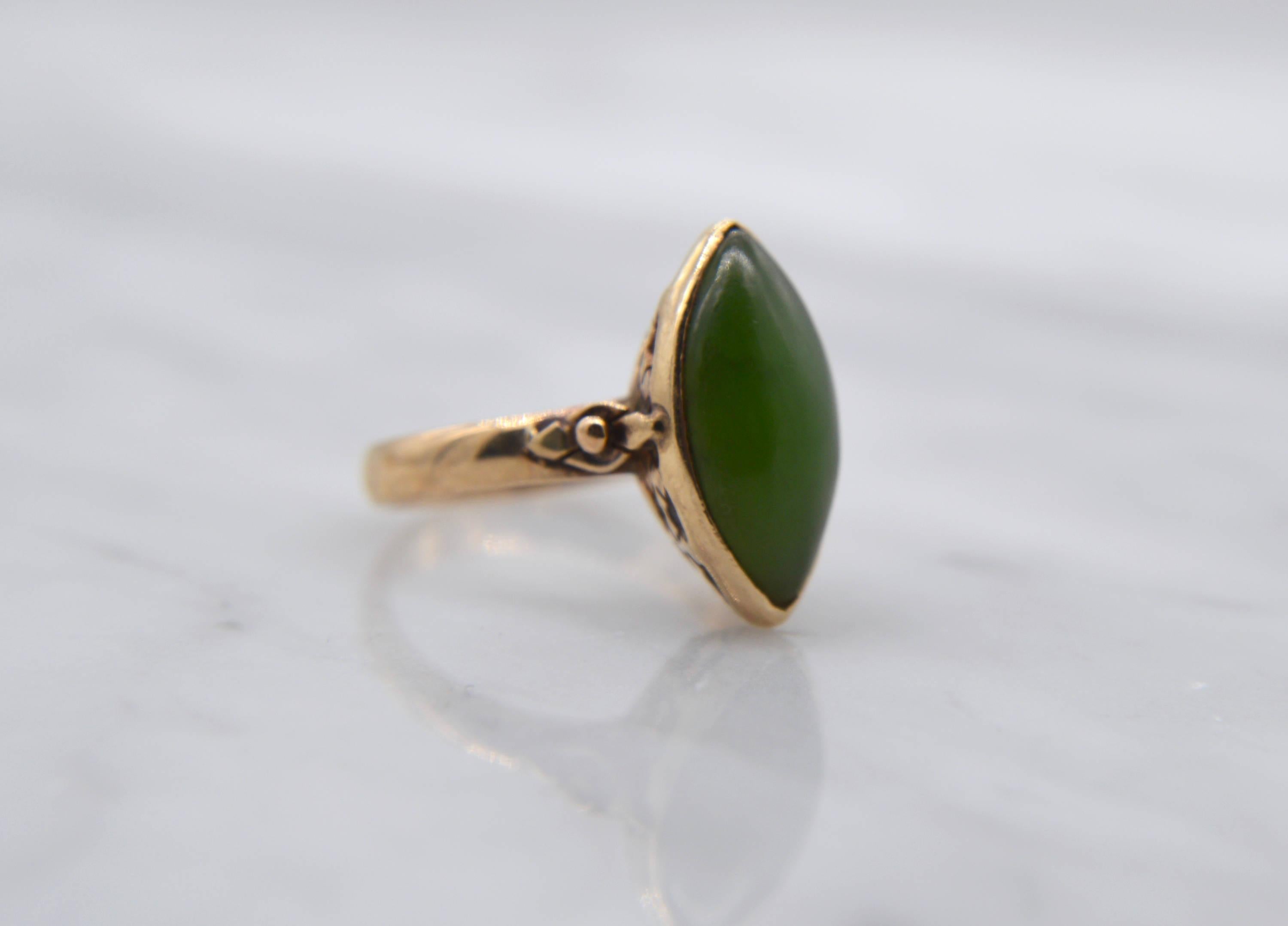 Beautiful Art Deco antique circa 1920s natural nephrite jade 14K yellow gold marquise cabochon ring. Mesmerizing shade of deep mossy green. In very good condition. Size 6, can be resized by a jeweler. Marked and tested as solid 14K. Cabochon