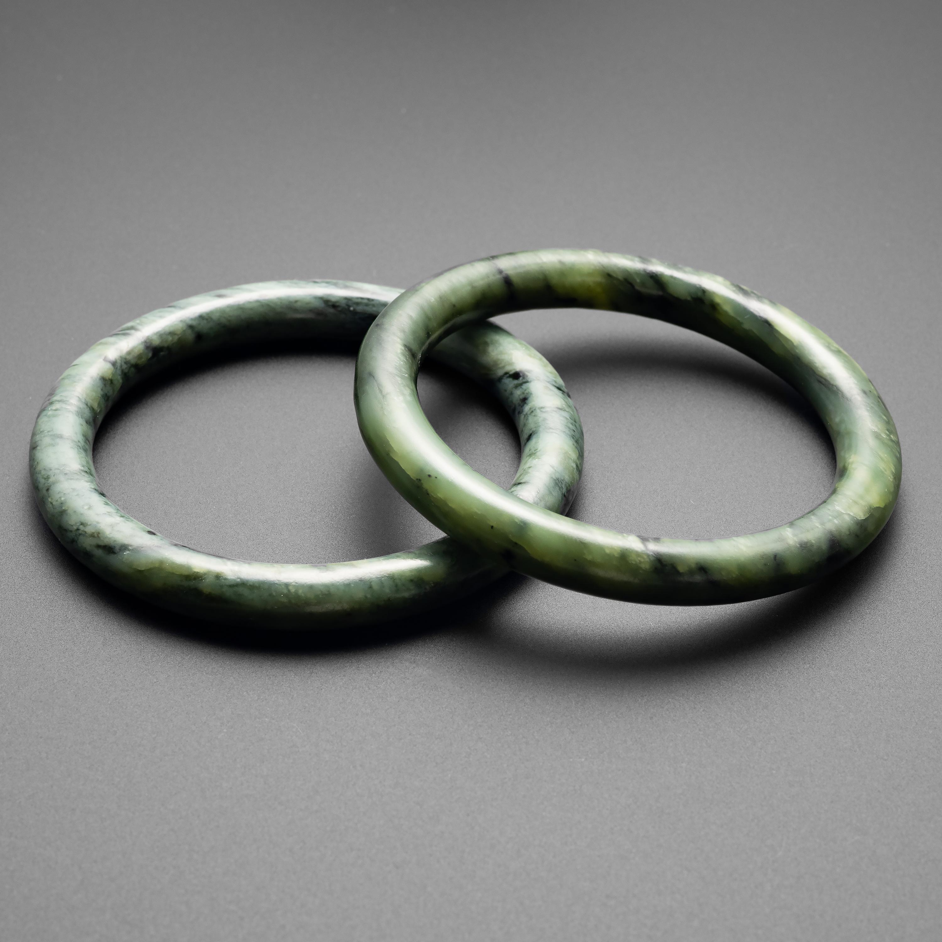 A pair of antique hand-carved and polished nephrite jade bangles dating to approximately 1900. I acquired these variegated green bangles as a pair and they do indeed appear to have been carved from the same piece of stone. Their pine-green coloring