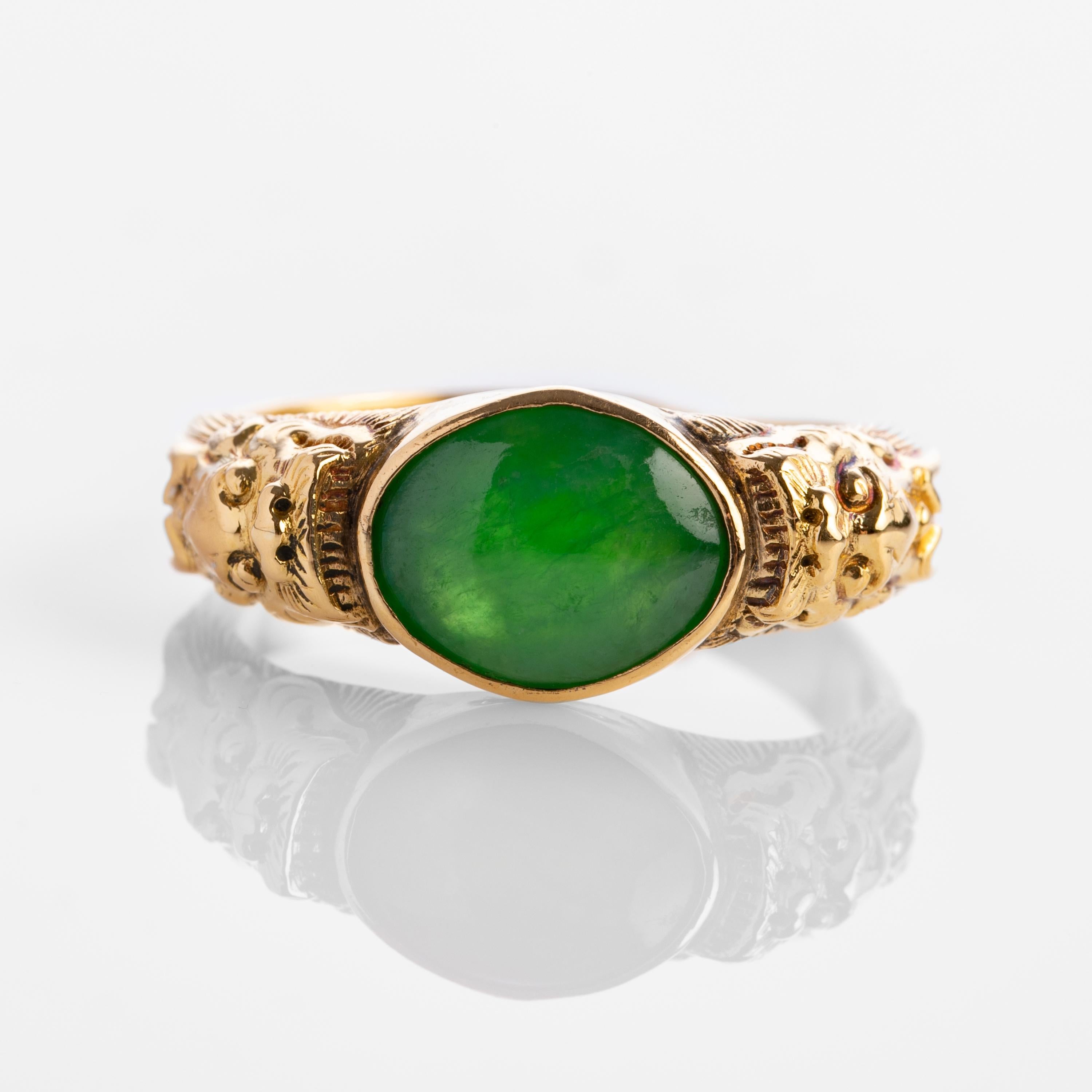 A fine antique ring rendered in sumptuous 20K yellow gold and featuring a 10.70mm x 8.60mm double cabochon of natural and untreated Burmese jadeite jade. The magnificent emerald-green jade stone has a beautiful antique polish that was created