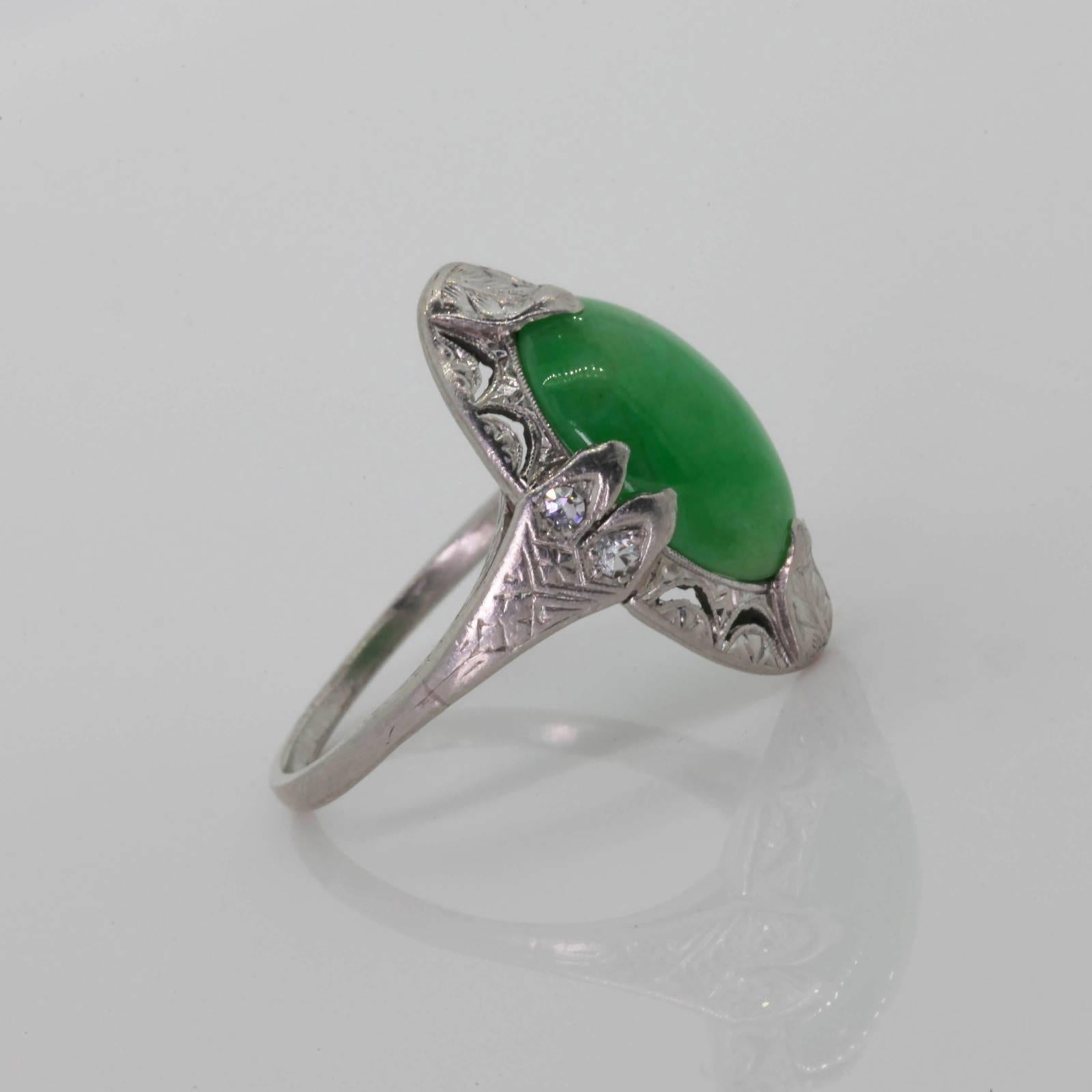 A coveted 1920s  North/South ring featuring an oval, cabochon lustrous Jadeite.  The setting is delicately designed with filigree and accented with two Single Cut Diamonds on each side.  Time worn engraving makes this beauty stand out! 
