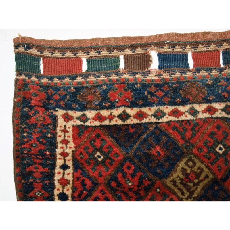 Antique Jaf Kurd bag face of diamond lattice design with good colour including blues, yellows and pinks.

The bag face is drawn with a rustic hooked medallion lattice, surrounded by a simple border. The bag face retains the closing lappets at the
