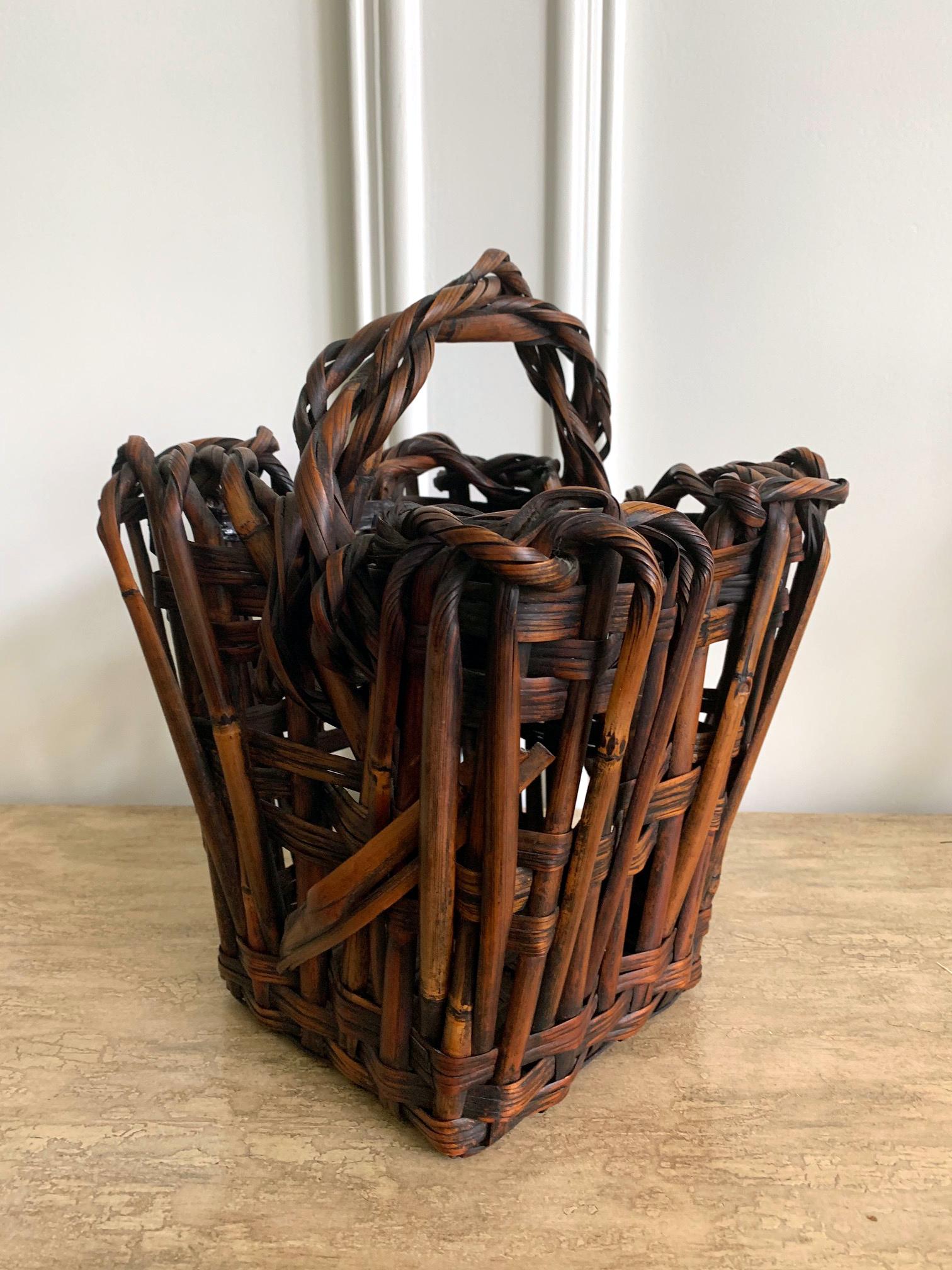A lovely antique Japanese Ikebana basket in a tapered square barrel shape with double handles. Made from smoked bamboo and rattan strips. Constructed with a loose parallel and irregular weaving, the more linear body rises to a freer form using bent