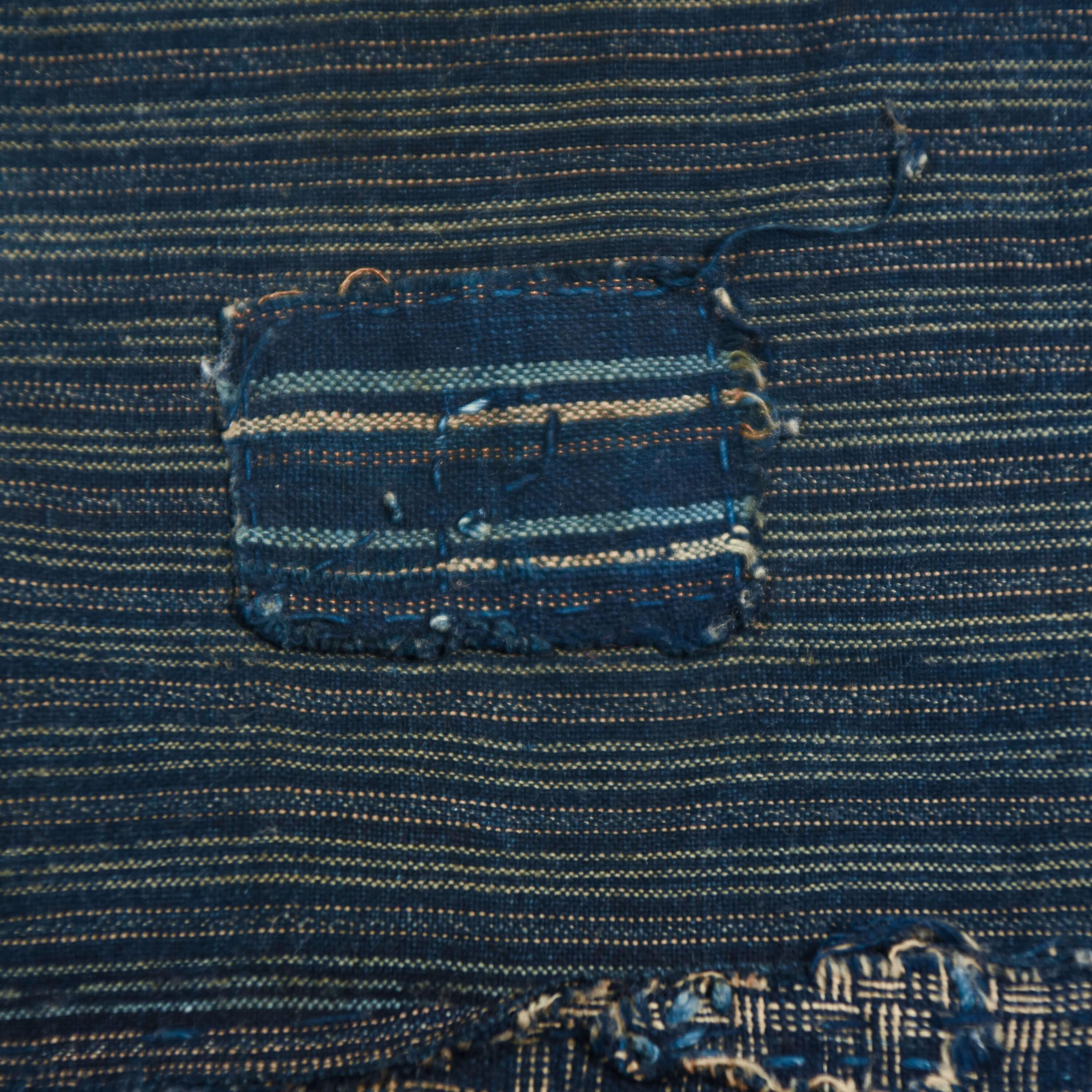 A Japanese Boro futon cover made from hand-dyed, hand-loomed indigo cotton. It has been repeated patched and mended. Boro textiles derive from the Japanese term boroboro, meaning tattered or worn and this is a beautiful example of the style. The